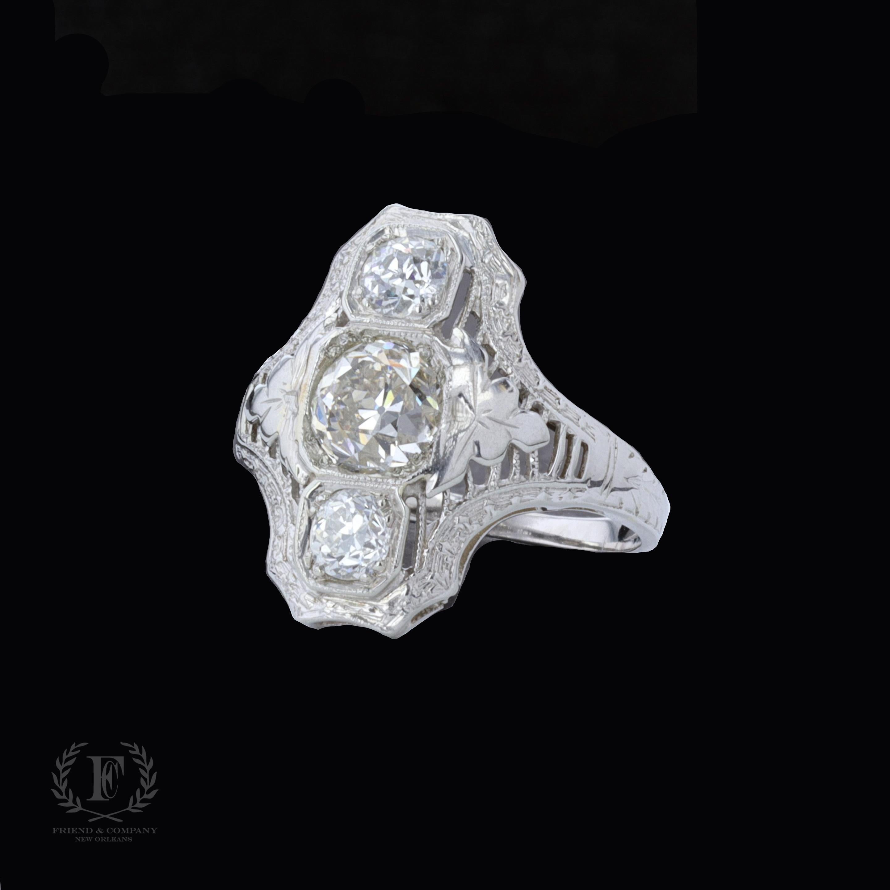 This decadent 14 karat Art Deco ring is centered with an old mine cut diamond that weighs approximately 1.03 carats. The color of the diamond is I-J with VS clarity. The center stone is accentuated by two old mine cut diamonds that weigh