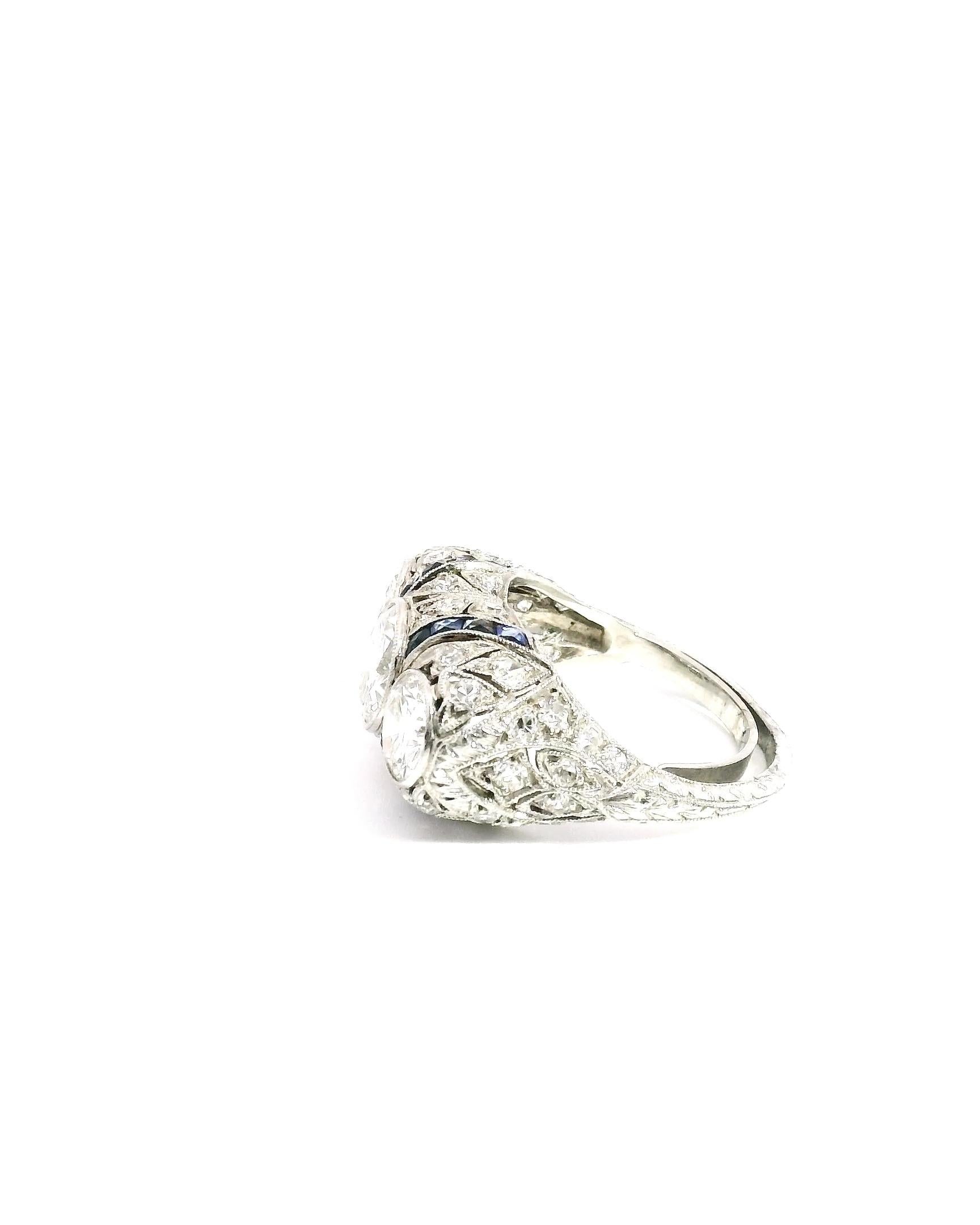 Art deco platinum filigree 3 stone ring.

Center dia. 1.20ct. Clarity grade is SI1 Color grade is I
1 Side diamond .75ct. Clarity grade is VVS2 Color grade is I
1 Side diamond .75ct. Clarity grade is VS1 Color grade is I
42 Single cut diamonds with