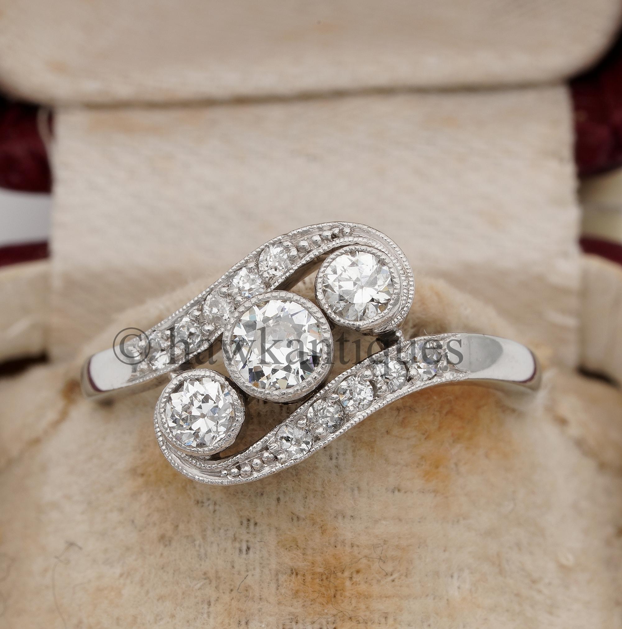 L'amour est en l'air
Magnifique bague Art déco à trois pierres et diamants, très bien fabriquée à la main, belle version torsadée ou croisée, comme c'était le cas à l'époque du Nouveau et du Déco.
Design/One de l'époque, or massif 18 carats surmonté