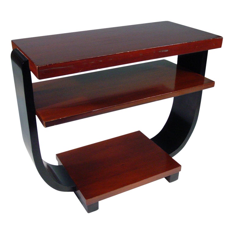These elegant Art Deco side tables by Brown Saltman feature curved black lacquer sides bracketing three mahogany shelves.
       