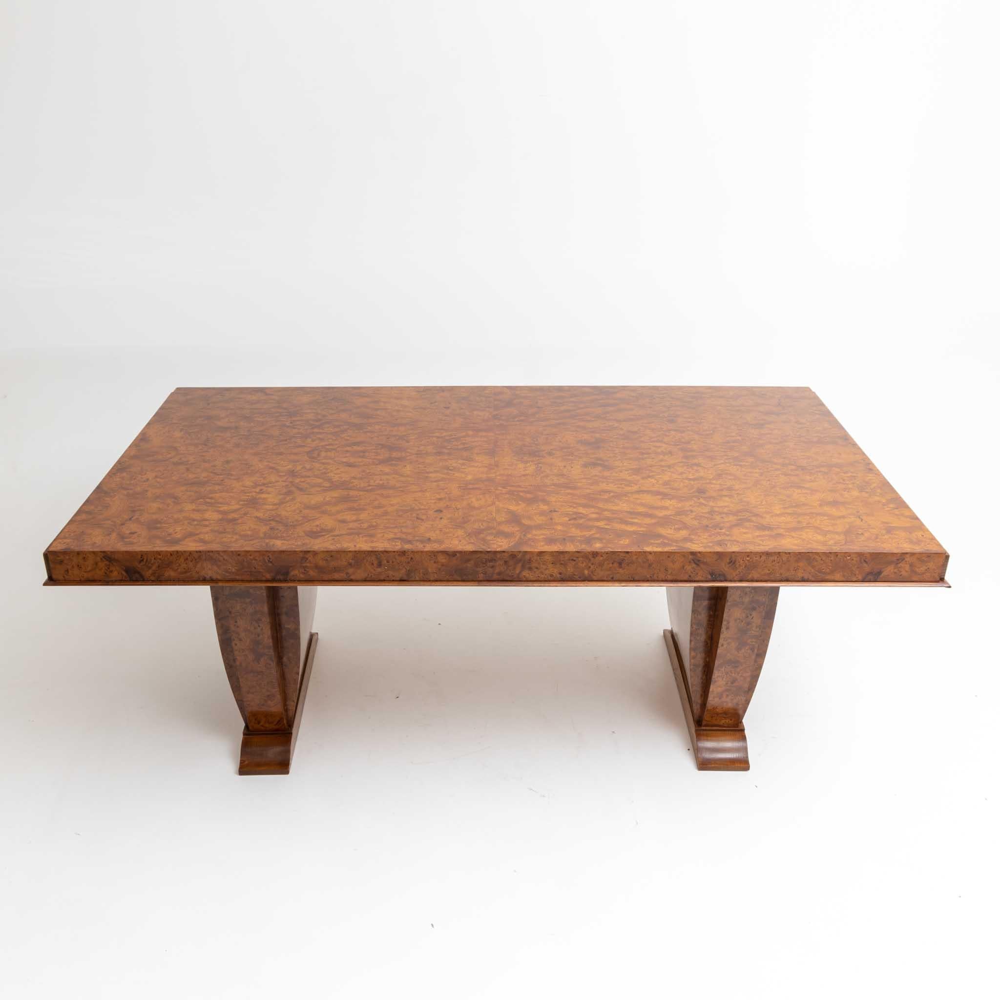 Art Deco dining table in Thuja root veneer with convex curved panels as legs. The table was hand polished in shellac and can seat six to eight people.