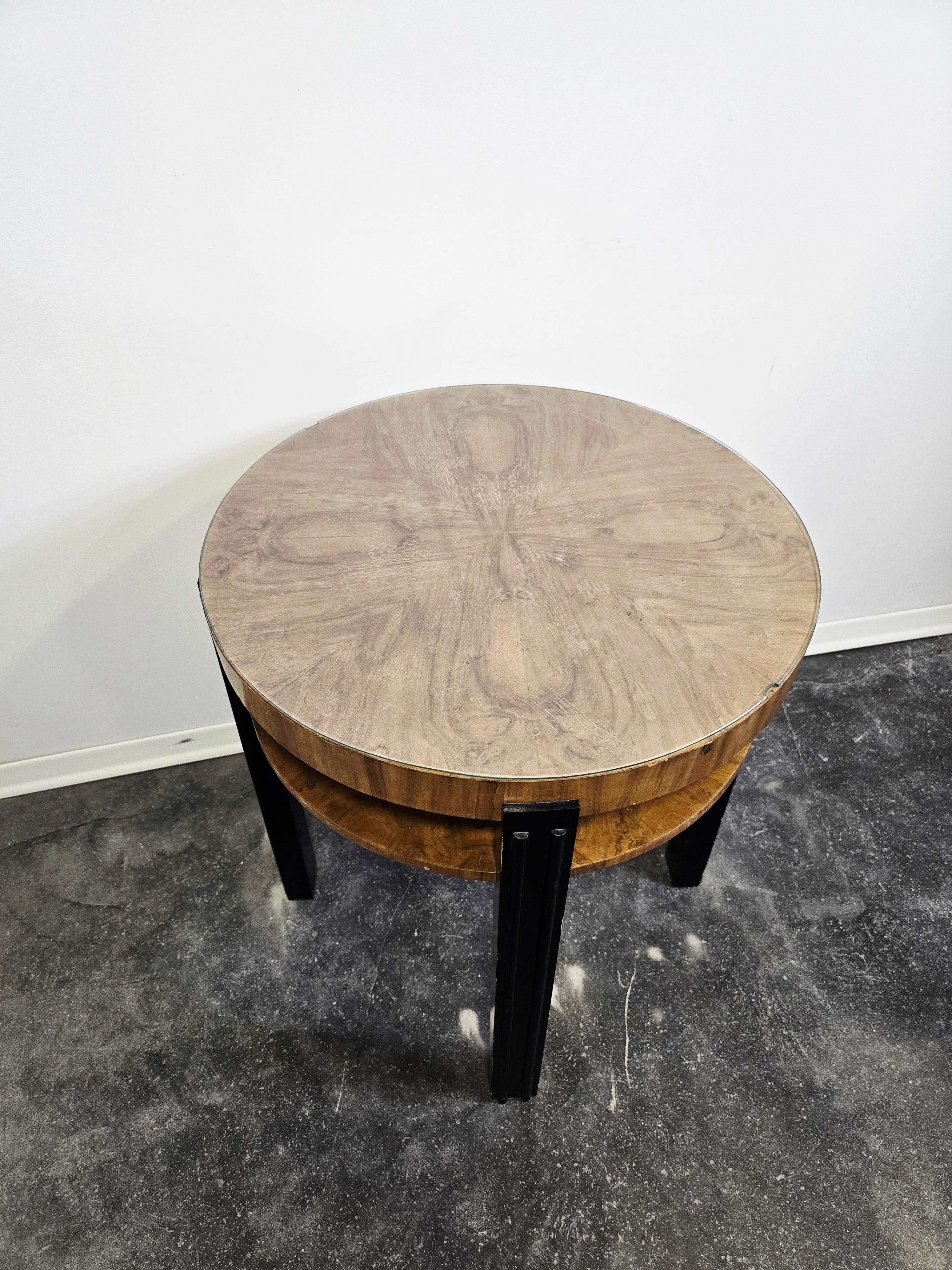 Dai un tocco di raffinatezza senza tempo ai tuoi interni con questo tavolino rotondo di ispirazione Art Déco. Realizzato in una ricca tonalità di legno e accentuato da eleganti gambe nere, questo pezzo cattura l'eleganza e l'armonia geometrica che