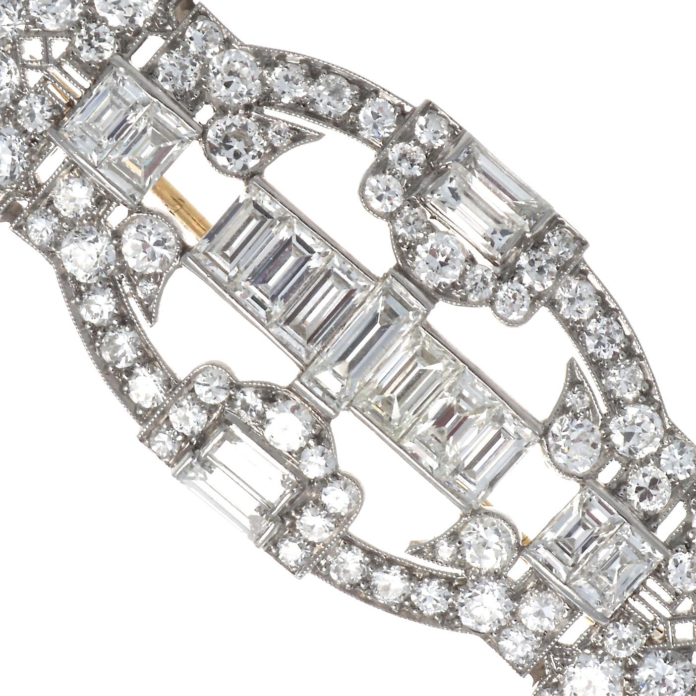 The perfection of Tiffany & Co. in classic Art Deco style; a platinum and diamond brooch. Approximately six carats of diamonds with 15 emerald cut diamonds weighing approximately 2.75 carats, F-G color and VS+ clarity.  Beautifully surrounded by 64