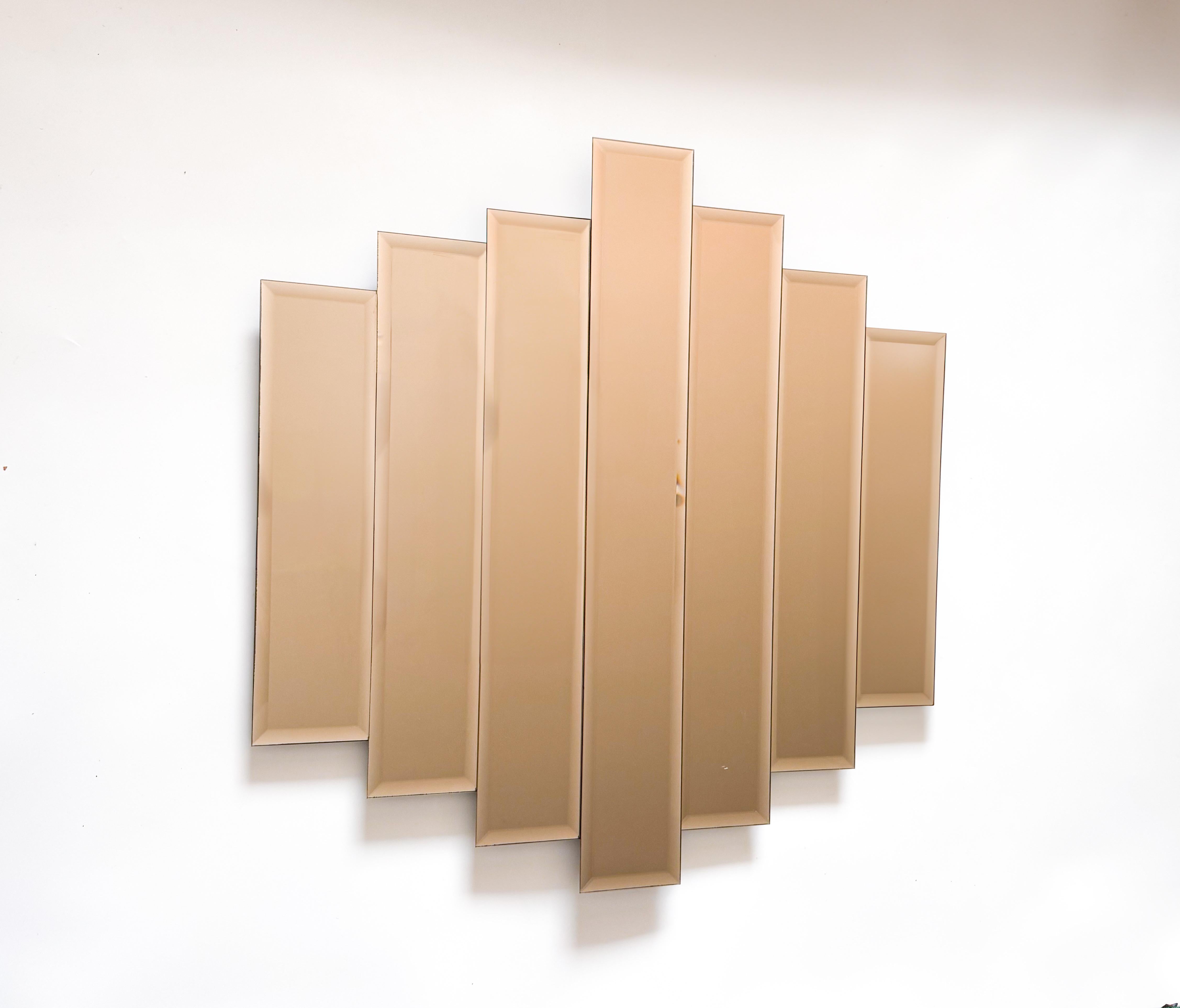A sculptural beauty from the 1980s, this rare Art Deco-style mirror features a stunning arrangement of seven stepped vertical panels in an unusual and sought-after pink/brown tint. The warm, subtle hue of the glass adds a sense of understated