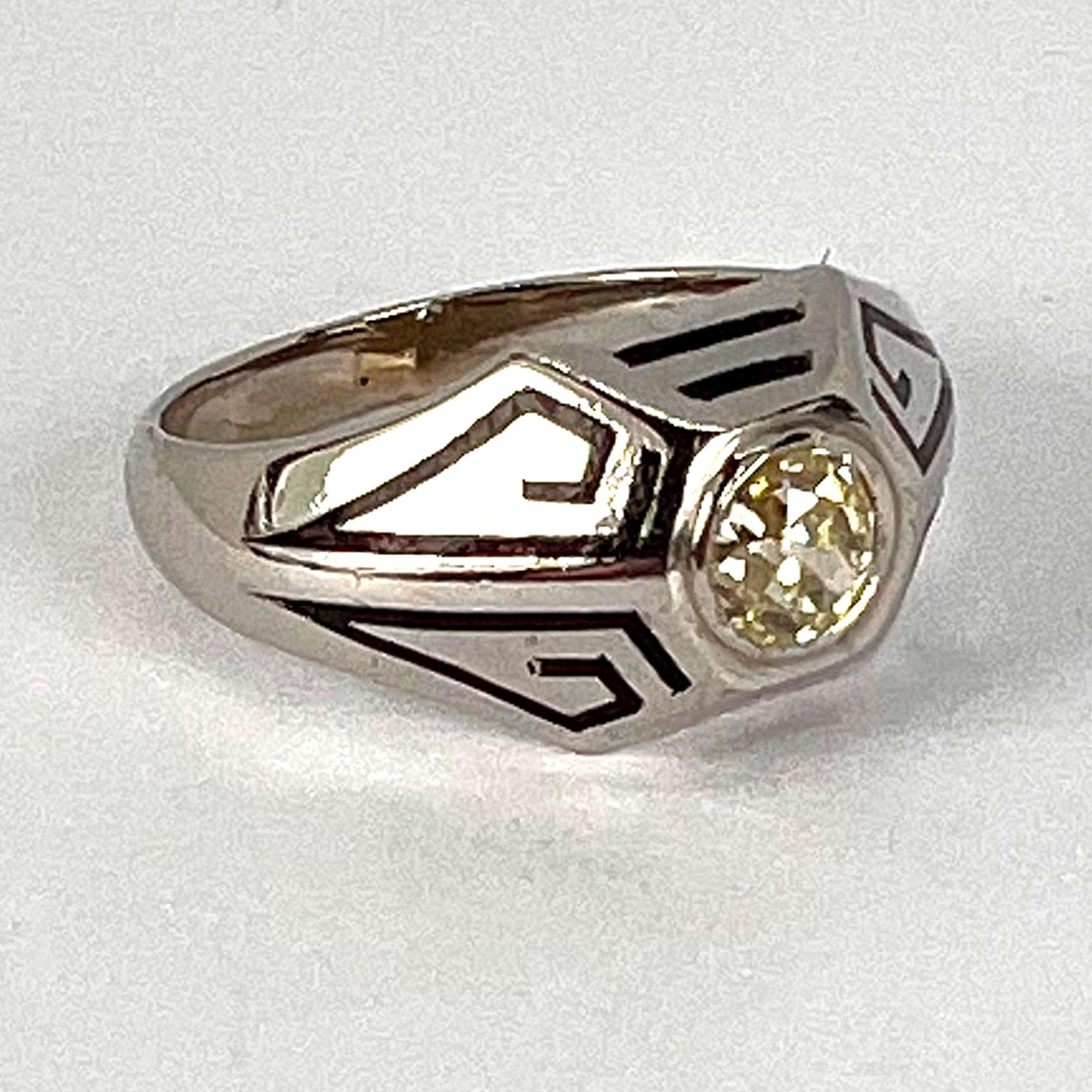 An Art Deco 14 karat (14K) white gold ring with geometric black enamel lines surrounding a tinted yellow Old European Cut diamond estimated to weigh 0.45 carats with V colour and VS clarity. Unmarked but tested for 14 karat white gold.

Ring size: