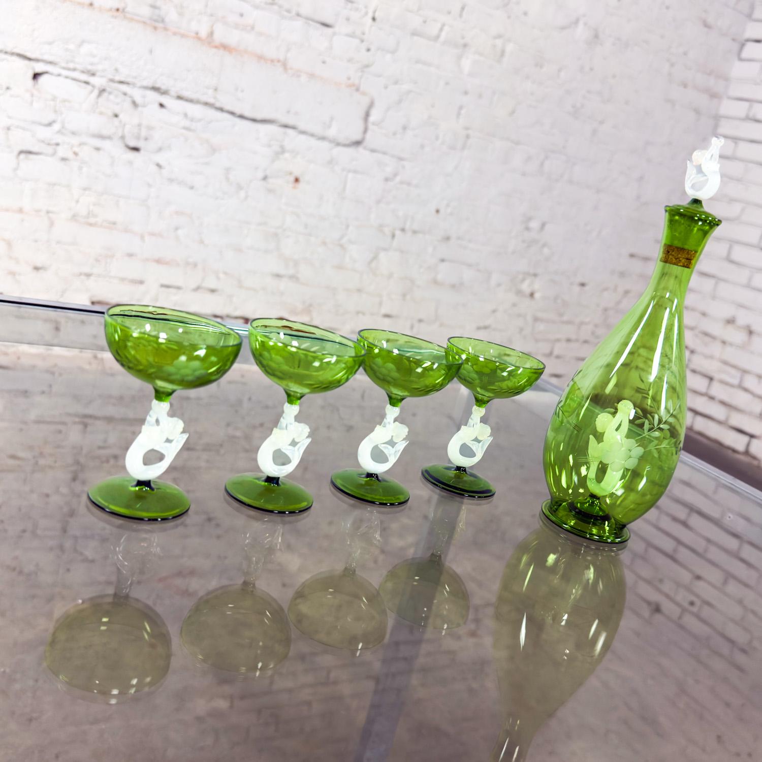 Meraviglioso set vintage in vetro artistico austriaco verde e bianco di The Artful Green & Greene, che comprende 1 decanter e topper e 4 bicchieri con steli di sirena e disegni floreali incisi sui bicchieri. Questo pezzo è stato attribuito sulla