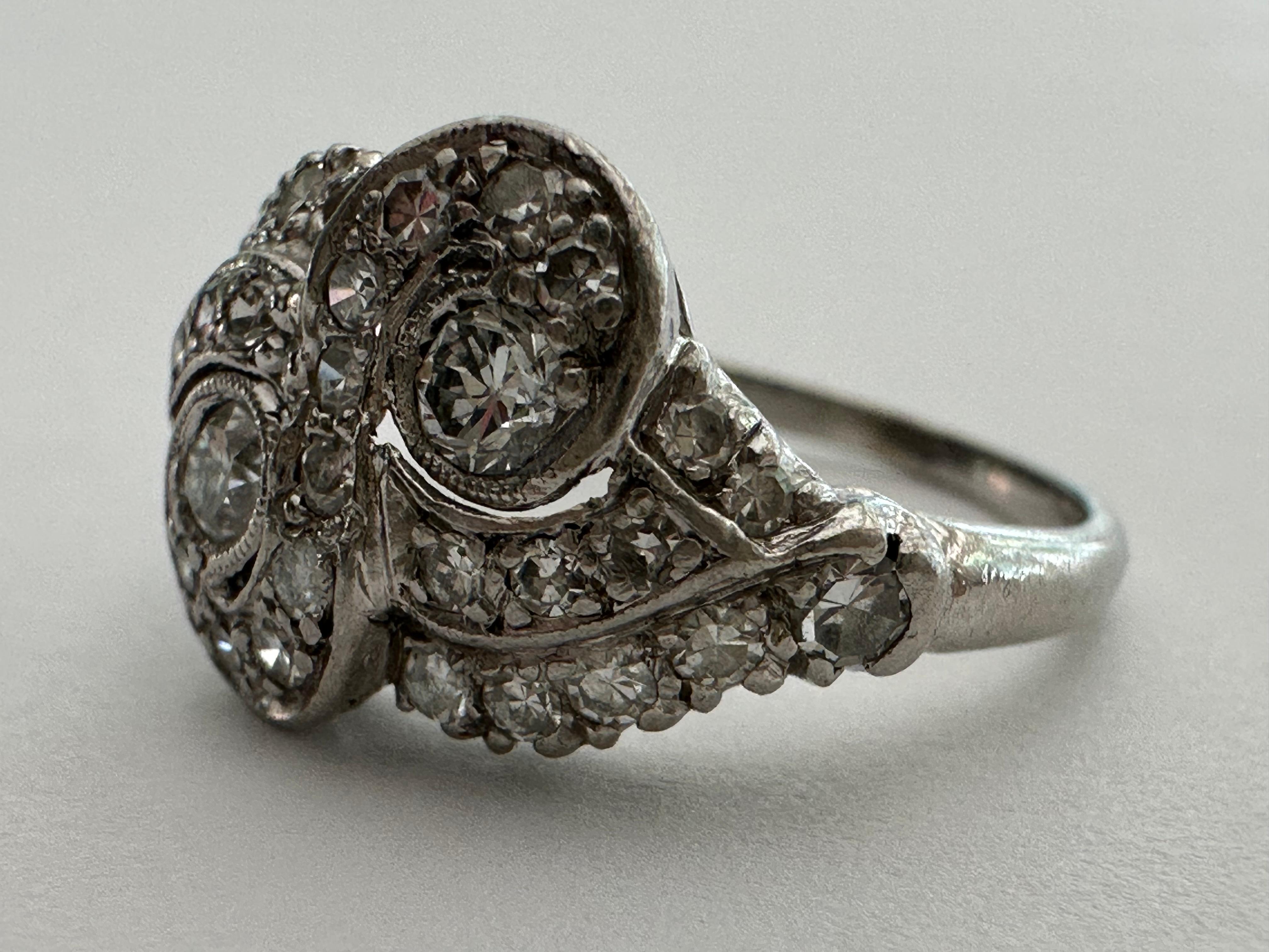 Este anillo Art Decó toi et moi presenta dos diamantes talla Vieja Europa de 0,10 quilates cada uno, color F claridad VS, y adornados con treinta diamantes talla única, color F claridad VS, que en conjunto pesan aproximadamente 0,60 quilates. El