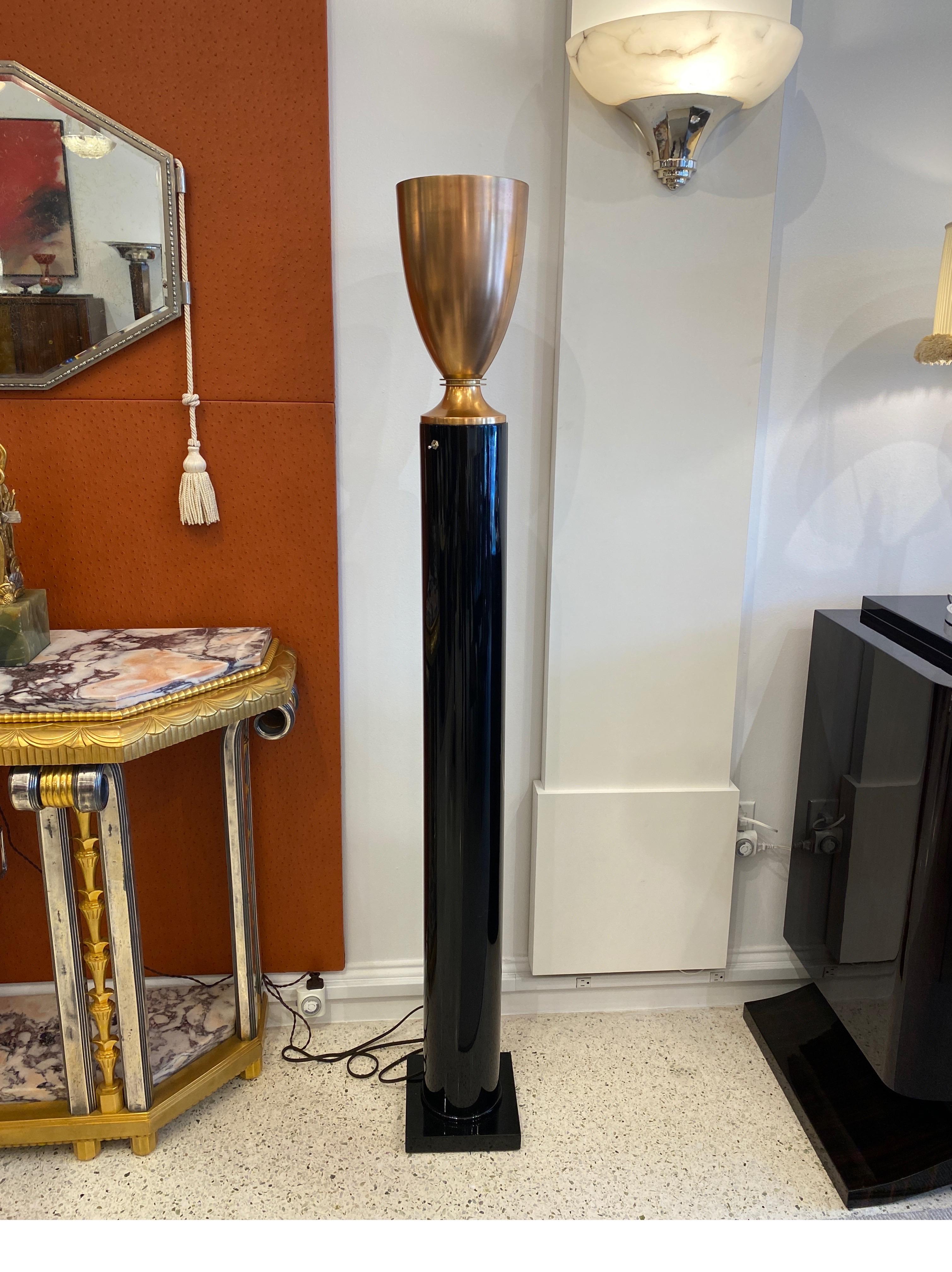 An Art Deco Black Lacquer Torchiere mounted in a stepped base with a Brass Shade.
Made in France 
circa 1930.