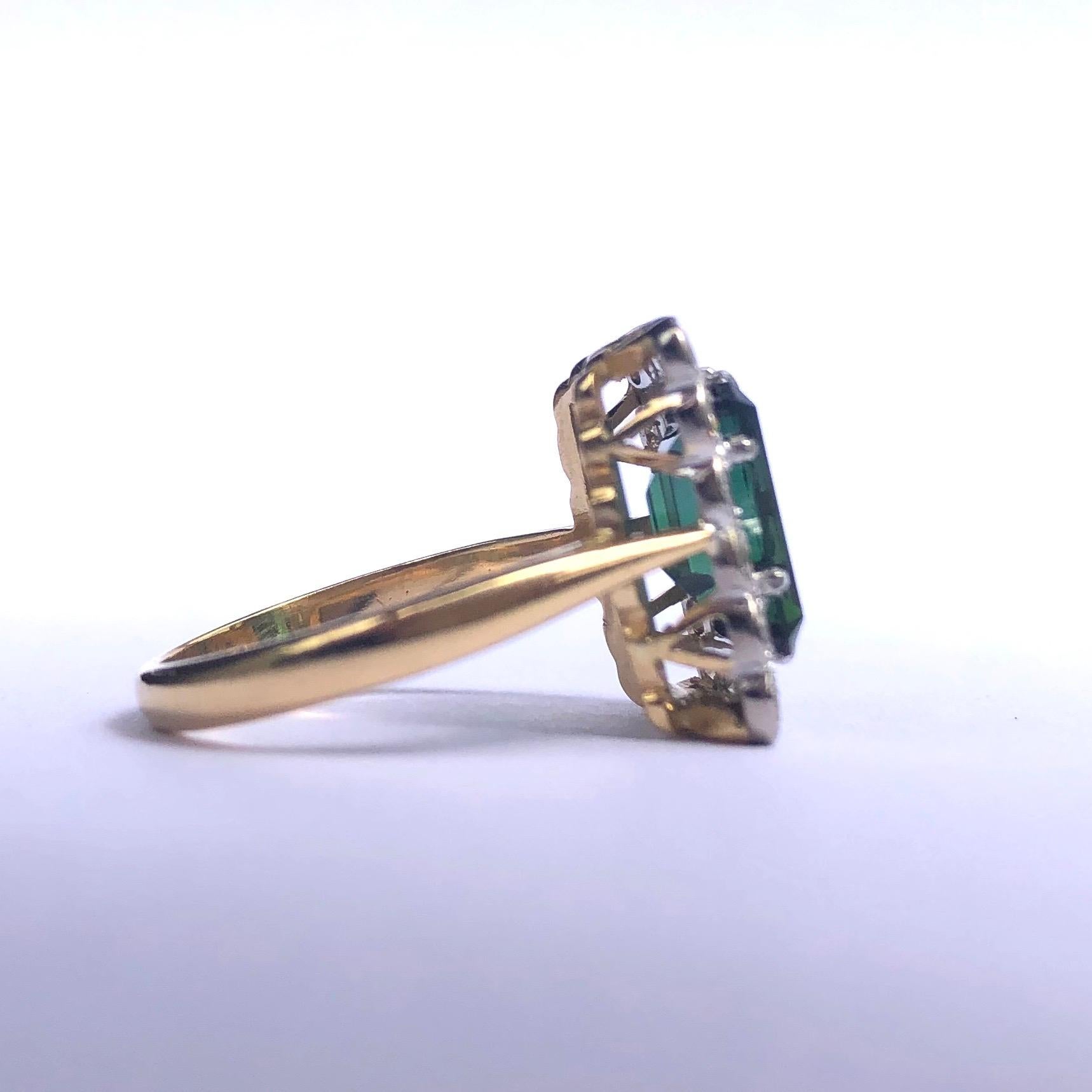 The tourmaline in this ring is a deep delicious green colour and is perfectly complimented by a halo of shimmering, bright white diamonds. The stones are set in platinum and the rest of the ring is modelled in 18ct gold. 

Ring Size: M 1/2 or 6 1/2