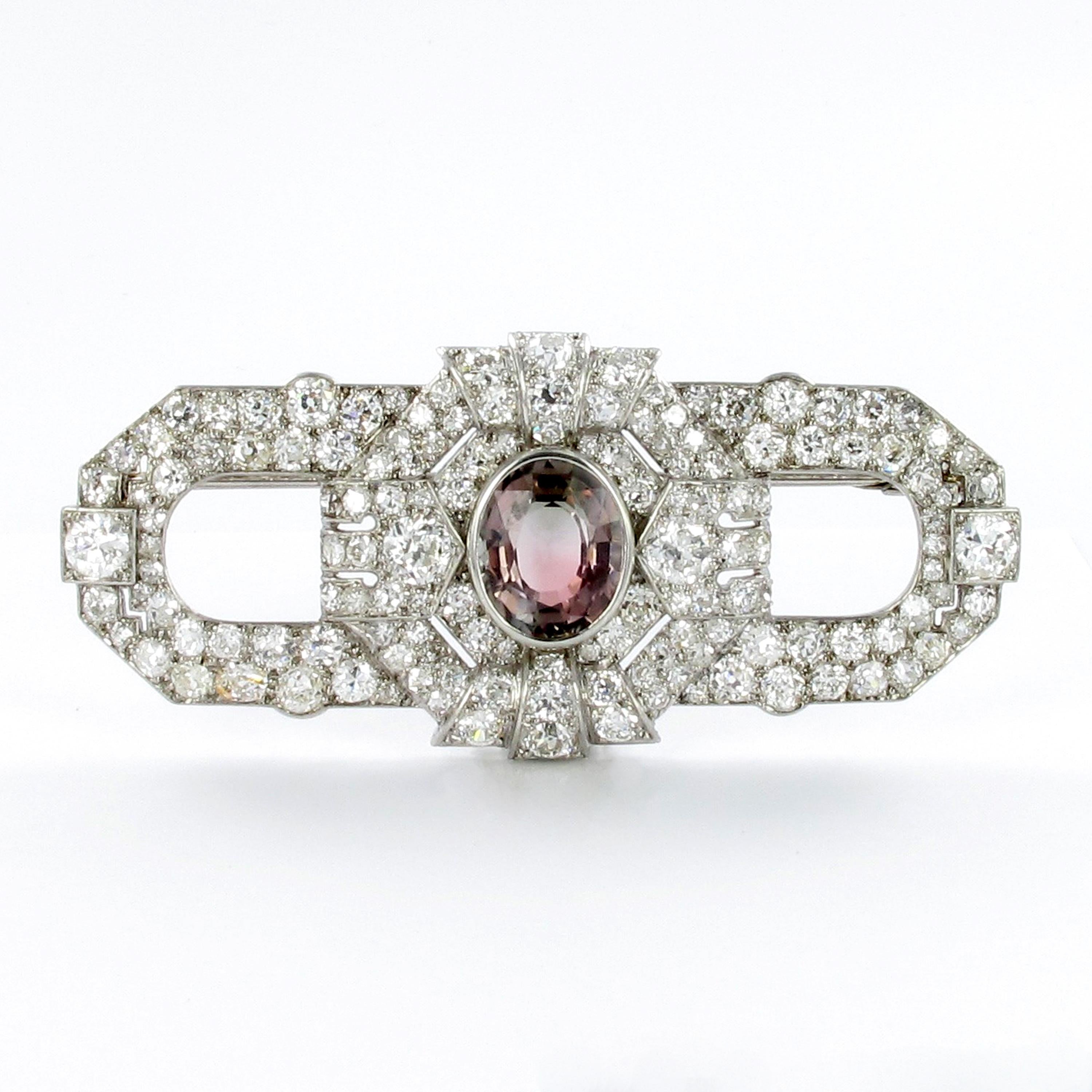 Decorative platinum brooch from the Art Déco period. Bezel set with a bicolor tourmaline of approximate 6 ct displaying peach and brow color…… Further set with 4 old European cut diamonds totaling 1.60 ct, finished with 138 old cut diamonds of
