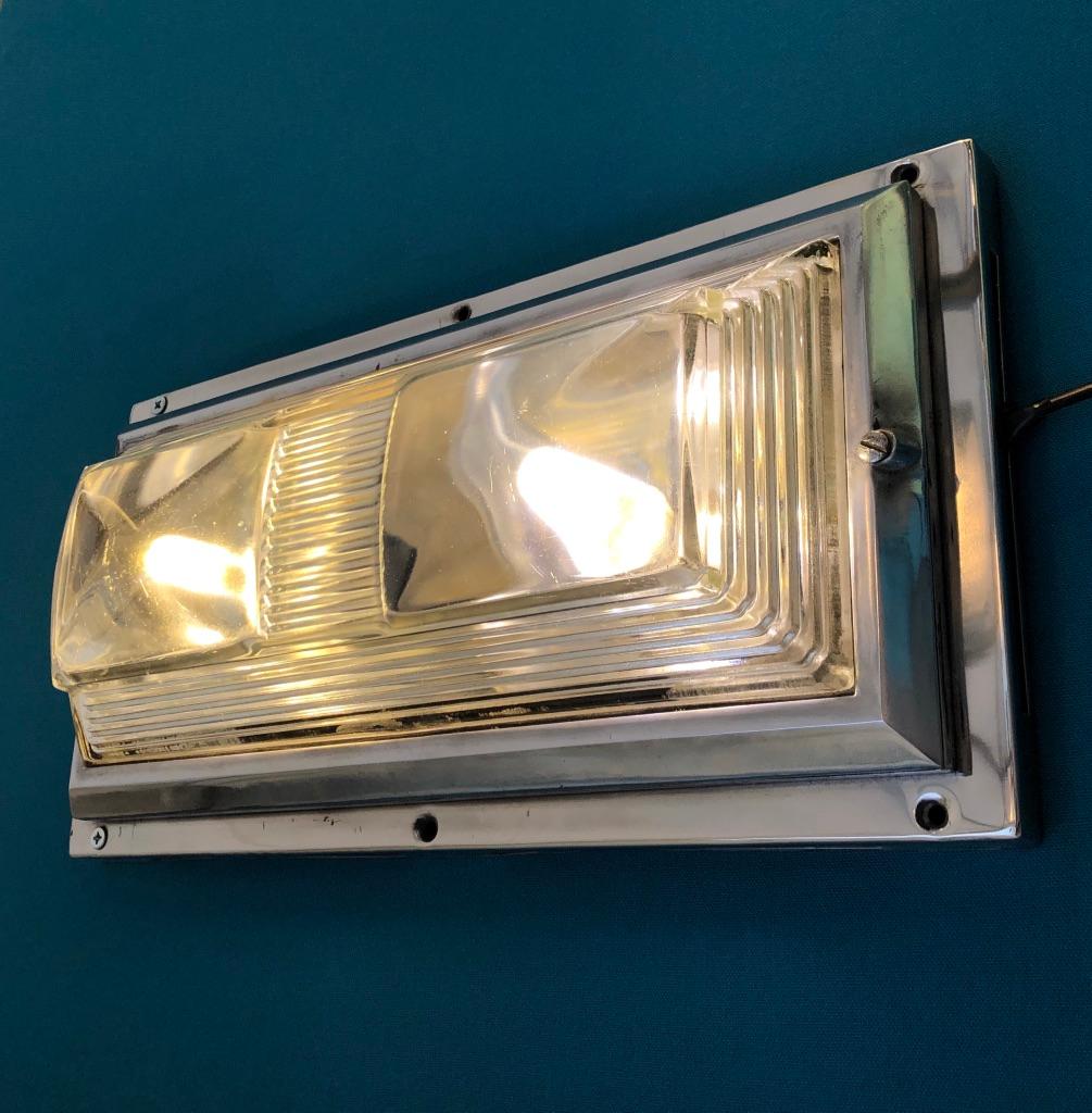 This wall or ceiling light is a rare find coming from an art deco train. The very thick and superb Saint Gobain glass has a modernist stepped shape and its roundness and softness is like those of a cabochon stone. A real gem!
The aluminum frame has