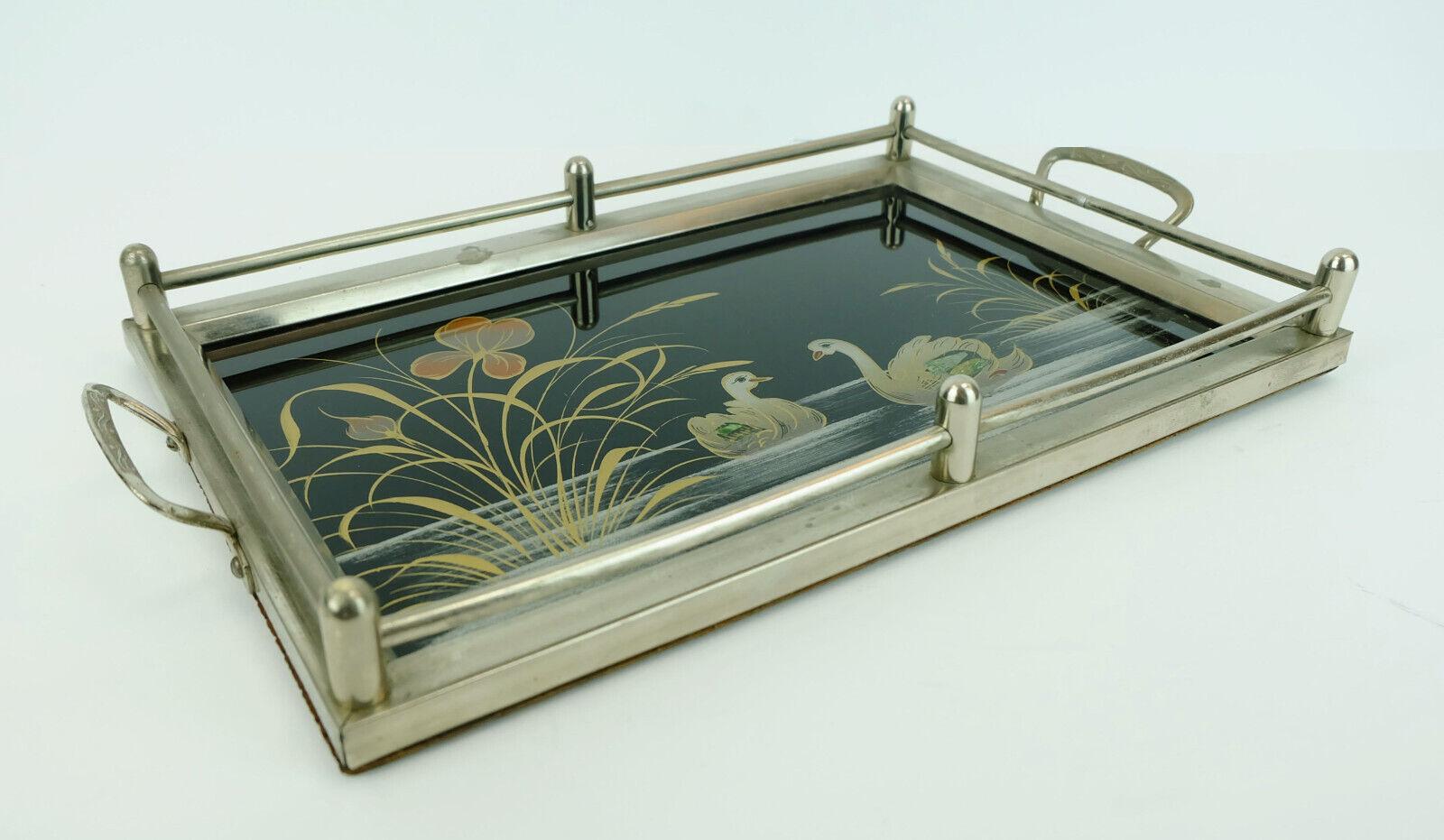 Beautiful old tray from the 1920s/30s. The base is made of glass and has a reverse glass motif depicting a pair of swans in a stretch of water with plants. The basic color is black, the motif is gold and bronze with some green and mother-of-pearl