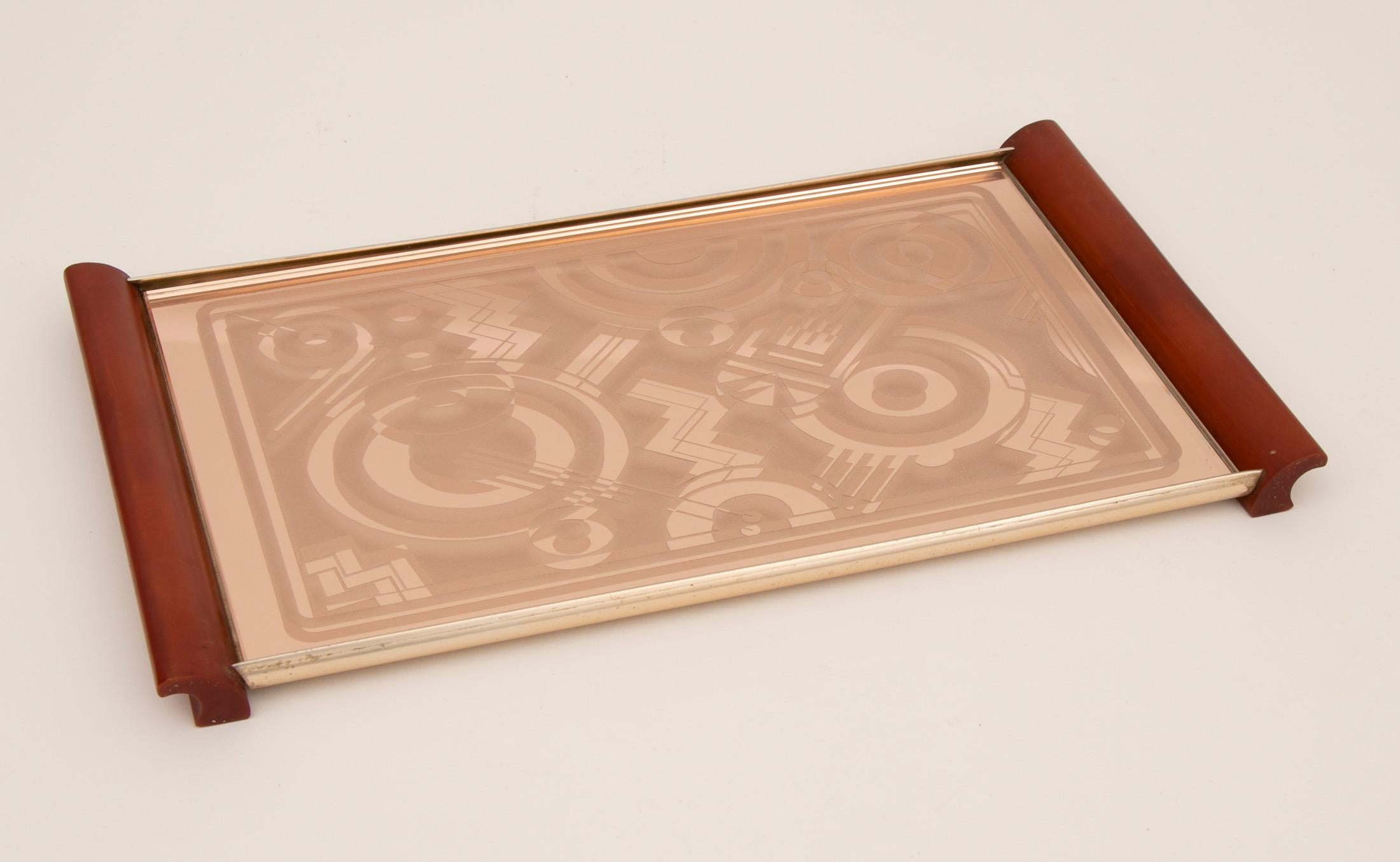Art Deco Tray with Amber Phenolic Handles and Peach Mirror glass with a superb geometric design, by Kaymet 
H: 2.5cm W: 40cm D: 22cm
French C1930