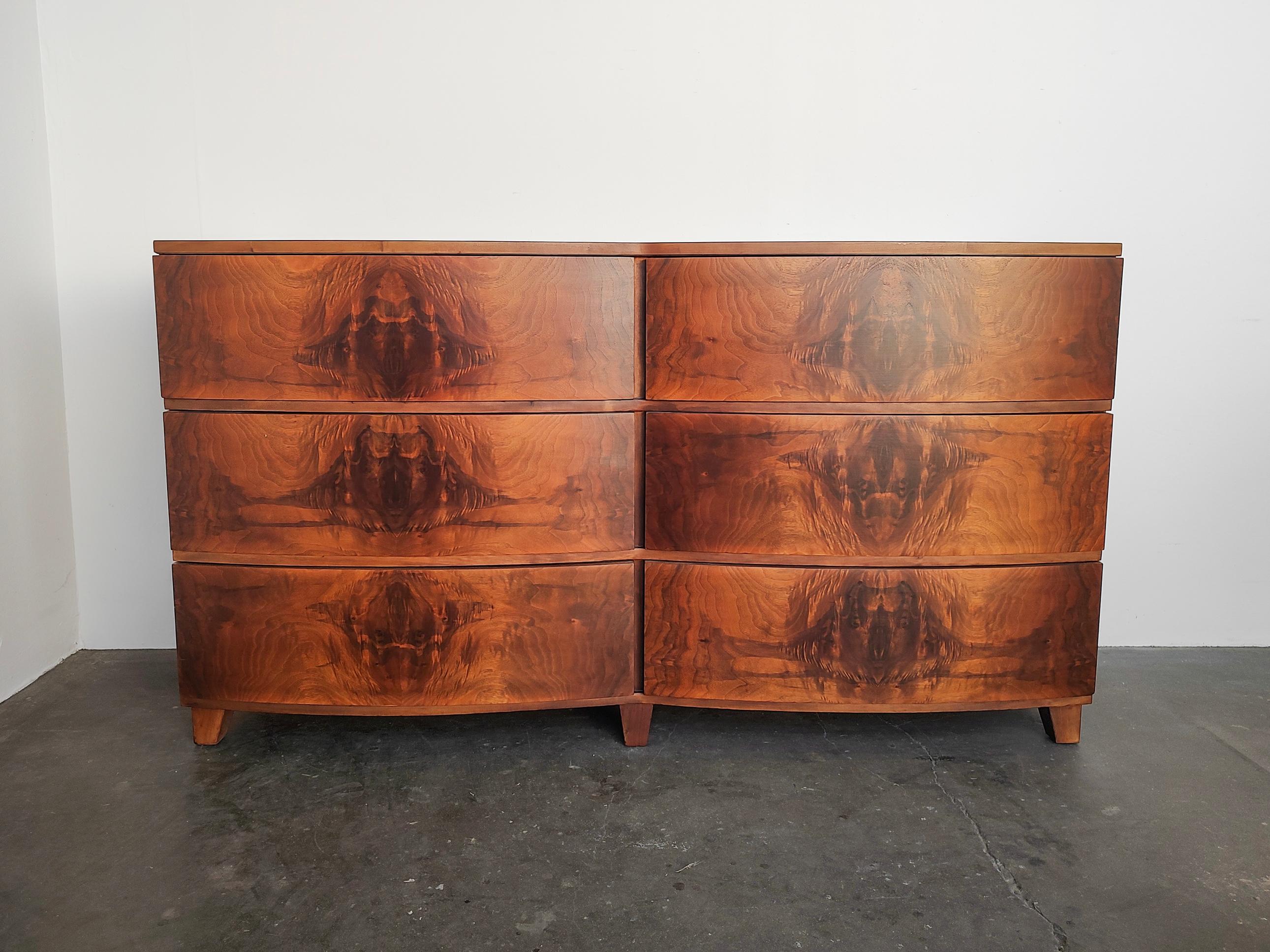 Professionally refinished Art Deco Tri-Bond Furniture lowboy dresser. Gorgeous walnut burl wood grain showcased on each of the six drawers with dovetail joinery. Minimal Art Deco double curved design. Overall excellent condition, a couple of areas