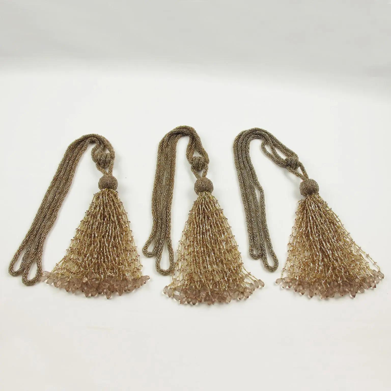 This is a lovely set of three Art Deco curtain tassel tiebacks or retainers. They are hand-made with crystal beads, faceted, and carved in assorted colors of gold, champagne, and light powder pink. These are beautiful quality decorations for any