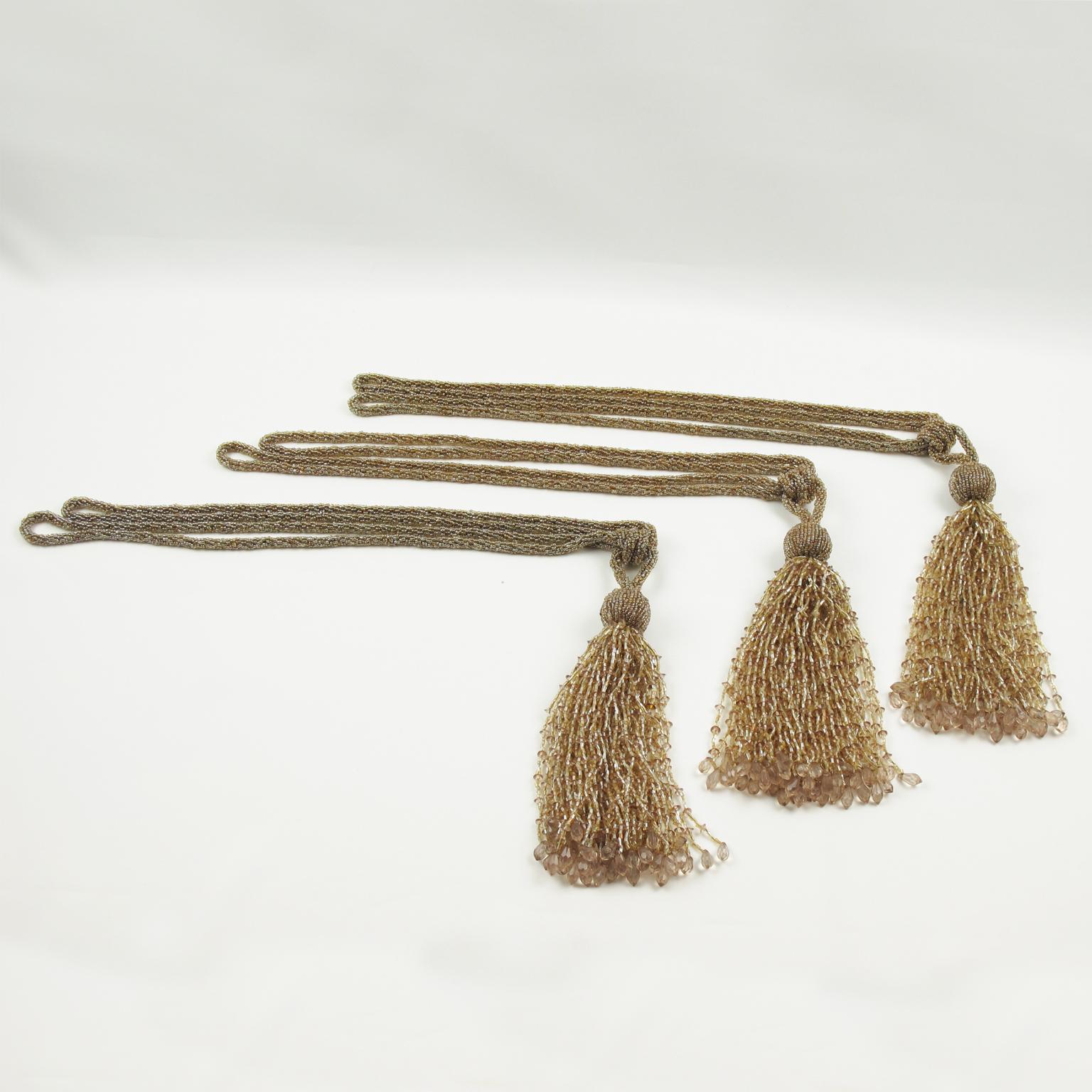 Si tratta di un grazioso set di tre nappe per tende in stile Art Déco. Sono realizzati a mano con perline di cristallo, sfaccettate e intagliate in colori assortiti di oro, champagne e rosa cipria chiaro. Si tratta di bellissime decorazioni di