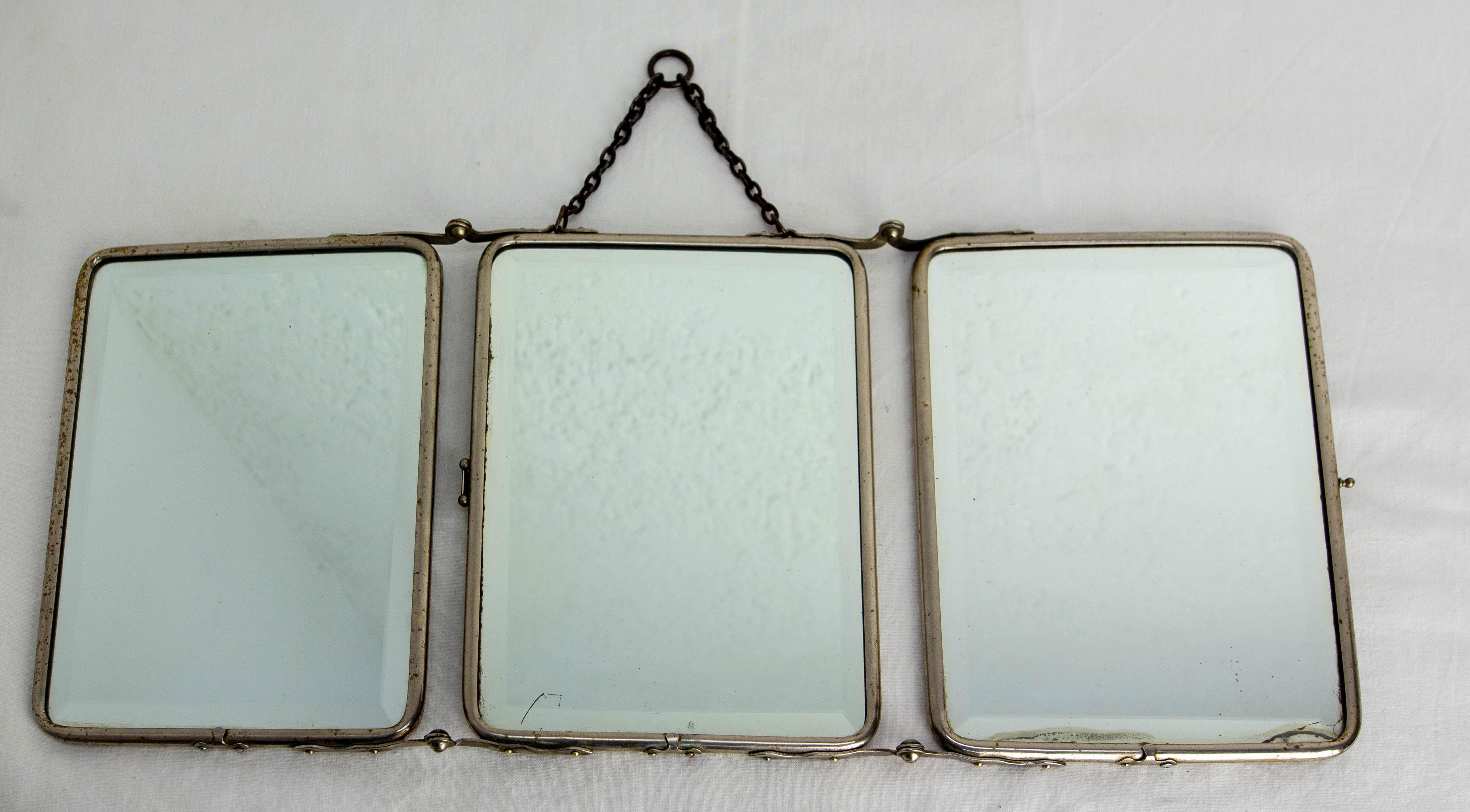 French barber mirror made circa 1930.
This kind of mirror has used  by the barbers. It was easily foldable, so it could be moved around the customer's premises. 
The three mirrors allow the face to be viewed from three different angles.
The three