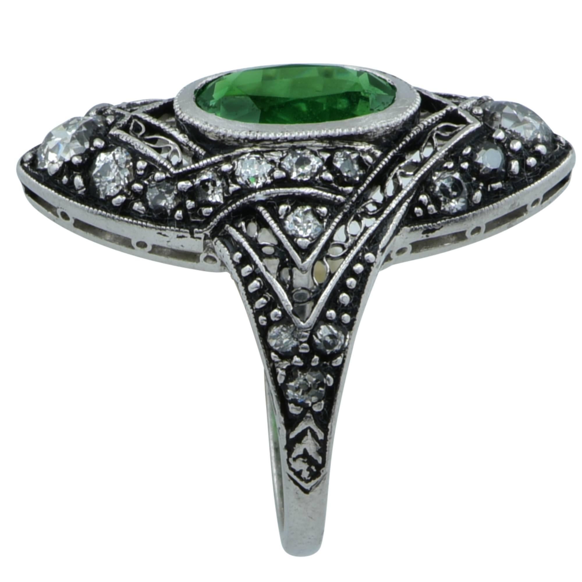 Art deco ring crafted in platinum featuring an oval cut 2.29ct rich green Tsavorite garnet accented by 24 European cut diamonds weighing approximately .50cts total, G color VS clarity.  This ring is currently a size 4.5 and can easily be sized. The