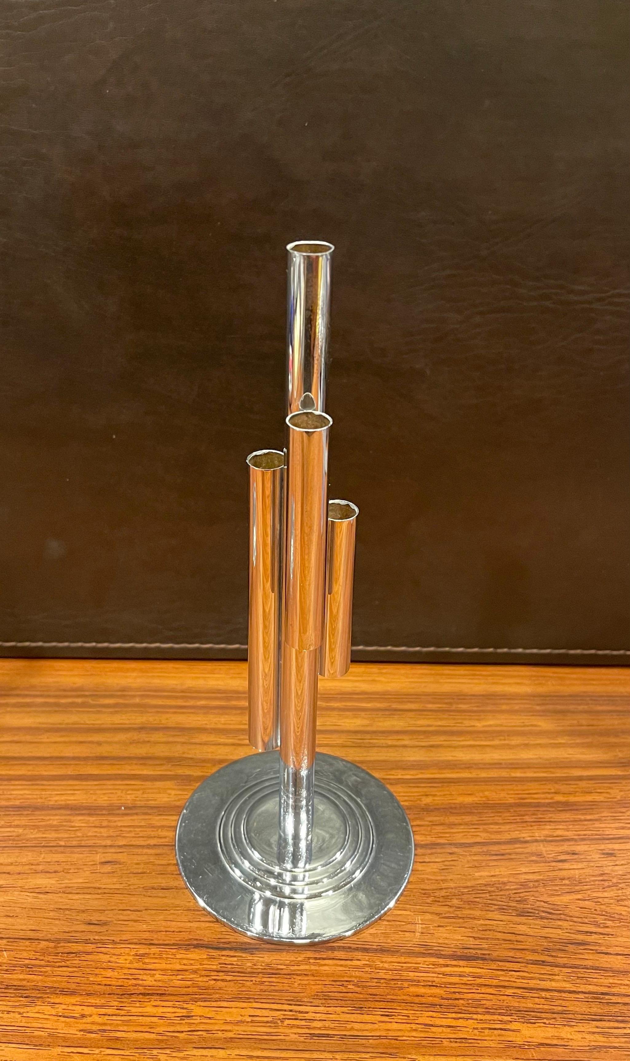 Wonderful Art Deco tubular chrome bud vase by Ruth & William Gerth for Chase & Co., circa 1930s. The design features a central chrome tube attached to which are three tubes of varying lengths and heights and mounted to a circular four stepped base.