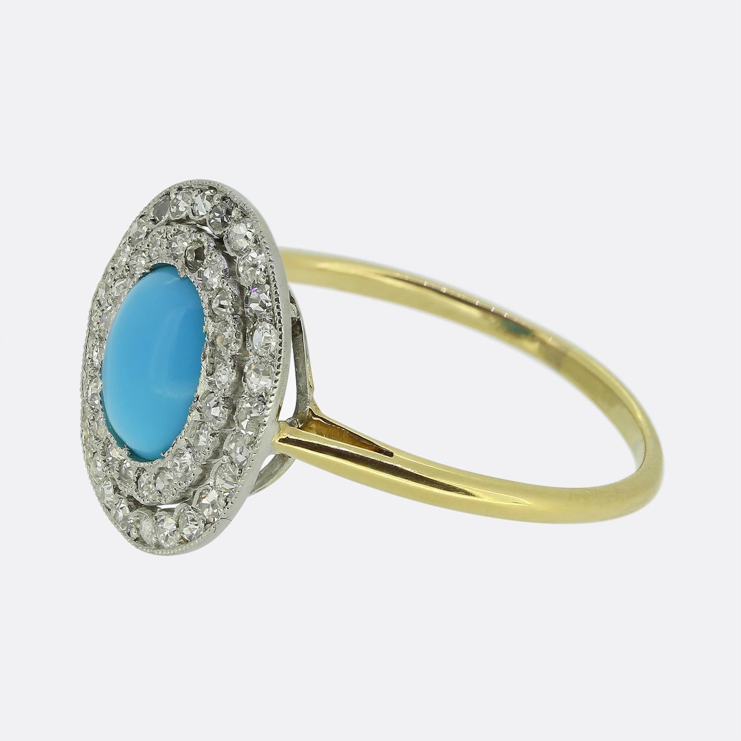 Hier haben wir einen fabelhaften Art-Déco-Cluster-Ring mit einem auffälligen blauen Türkis-Cabochon in der Mitte. Um diesen Hauptstein herum befindet sich ein doppelter Halo aus runden, facettierten Diamanten im Minenschliff, von denen jeder einen