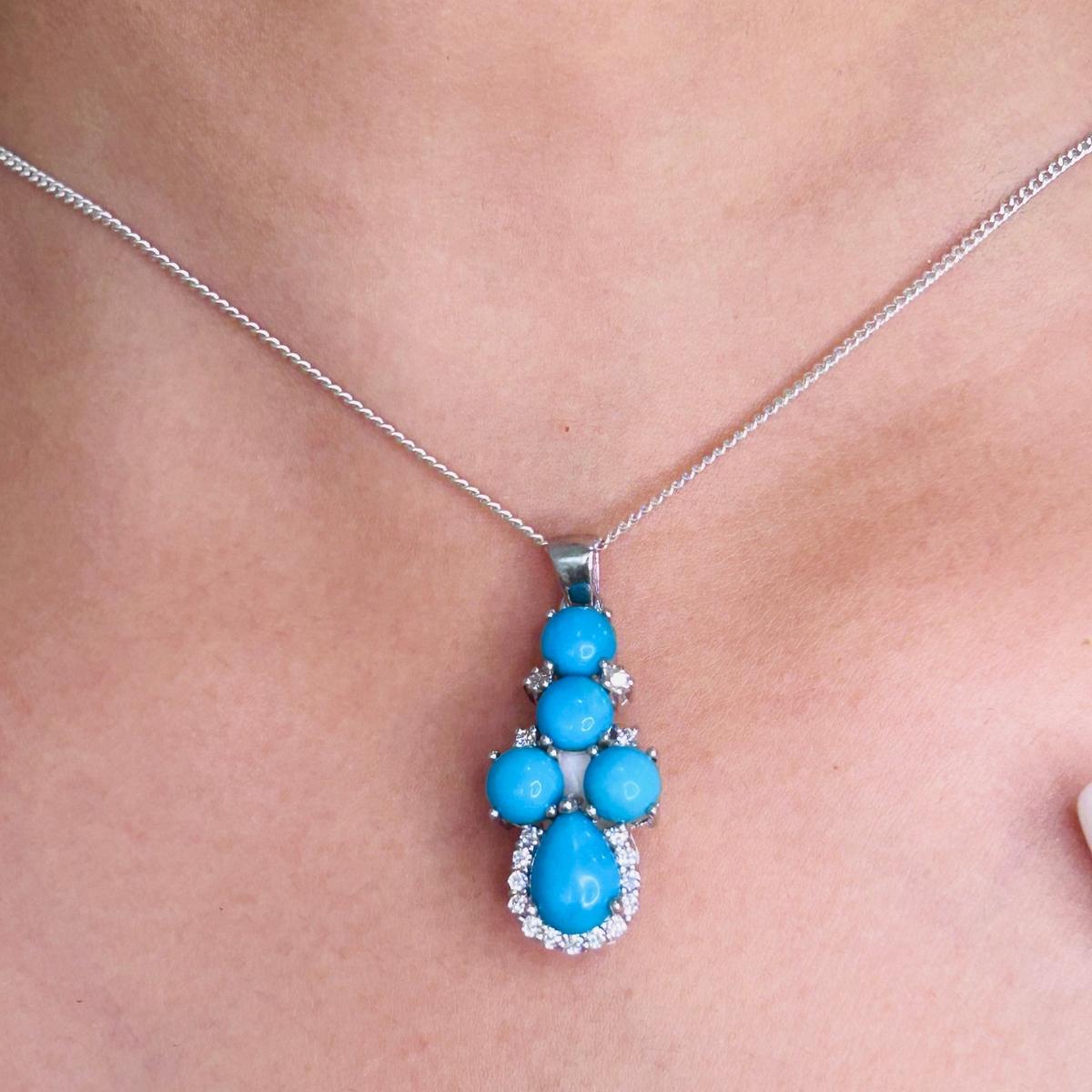 Art Deco Style Turquoise December Birthstone Pendant in sterling silver studded with round, pear cut turquoise. This stunning piece of jewelry instantly elevates a casual look or dressy outfit.
Turquoise enhances the intellectual capacity of the