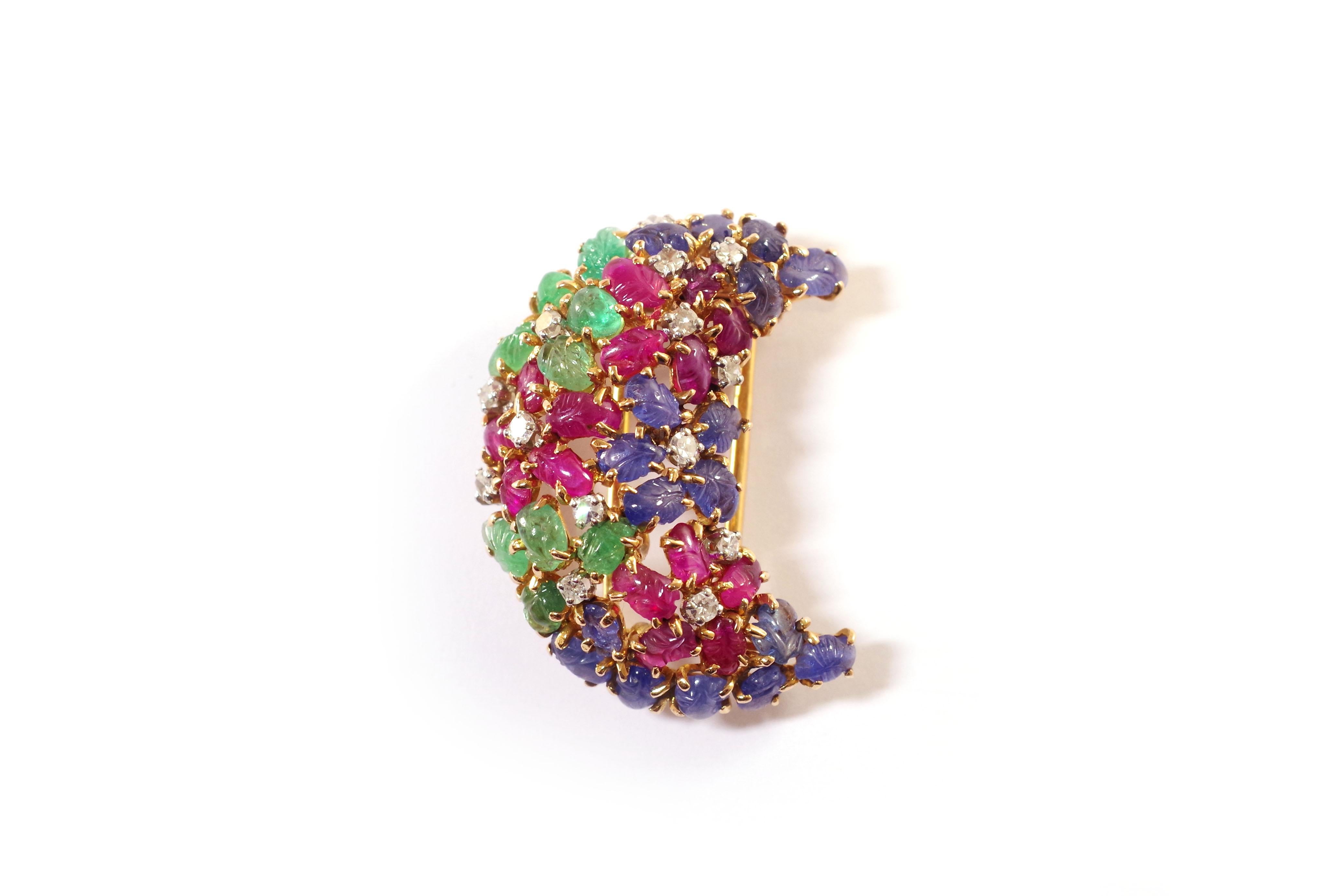 Art Deco Tutti Frutti clip brooch in 18 karat gold and platinum. Brooch taking the form of a crescent moon, decorated with flowers stylized by petals carved with sapphires, rubies and emeralds, the pistil represented by single cut diamonds. This