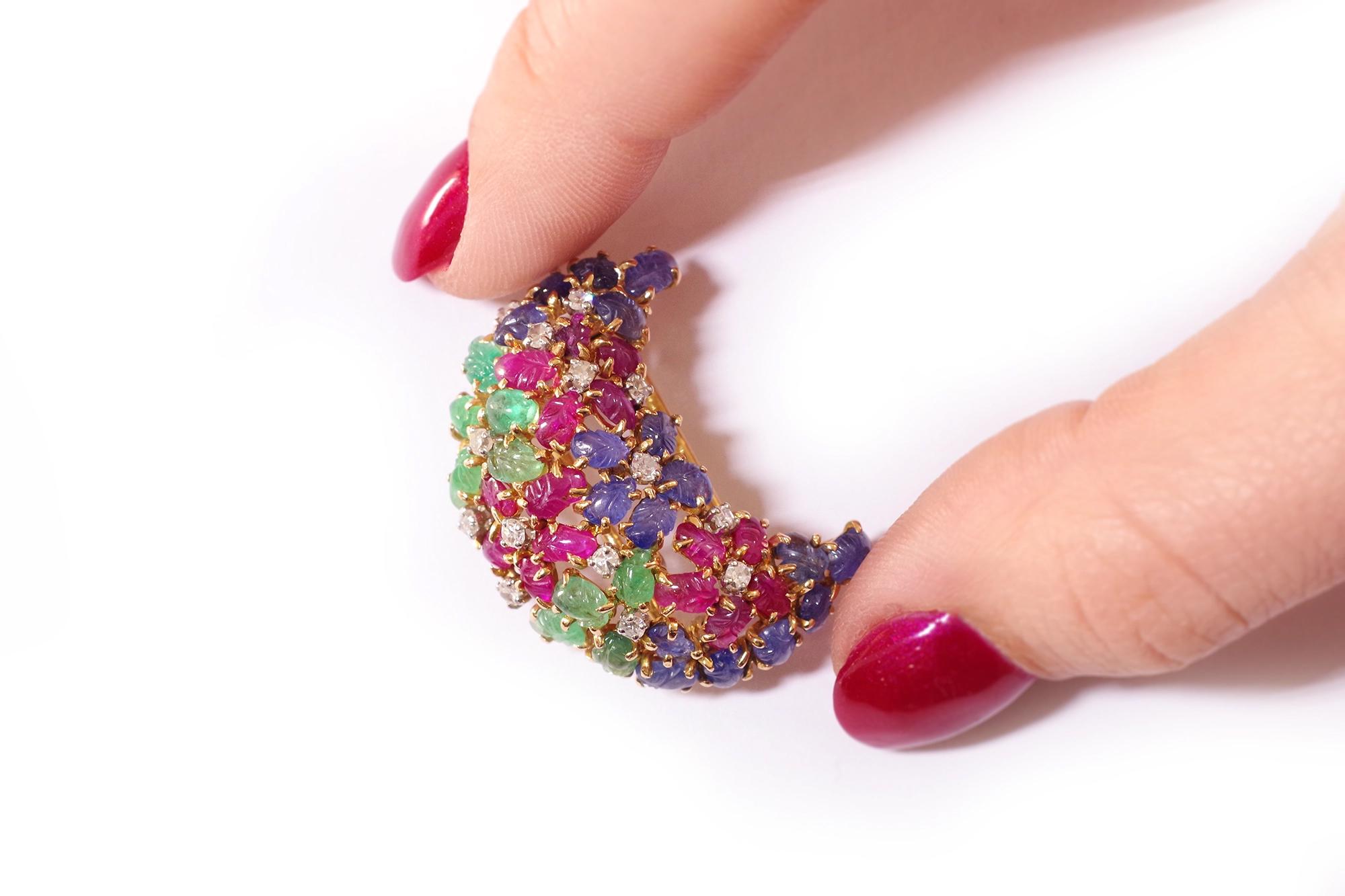 Art Deco Tutti Frutti clip brooch in 18 karat gold and platinum. Brooch taking the form of a crescent moon, decorated with flowers stylized by petals carved with sapphires, rubies and emeralds, the pistil represented by single cut diamonds. This
