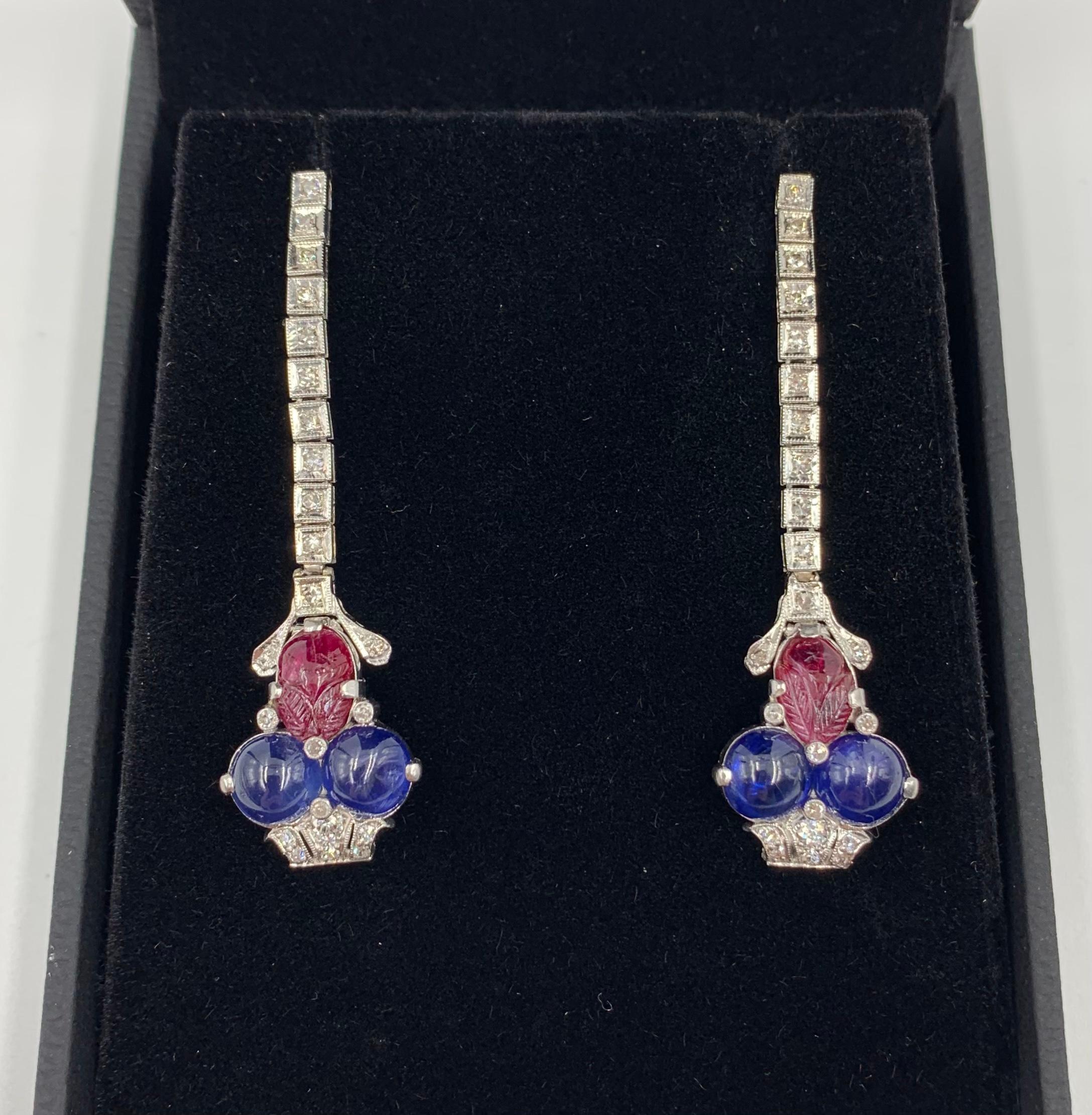 Exquisite Art Deco period Tutti Frutti diamond, cabochon sapphire, carved ruby platinum earrings.
Circa 1920
Each designed as a stylized diamond basket laden with large, luscious cabochon sapphire fruit with a beautifully carved ruby leaf on an