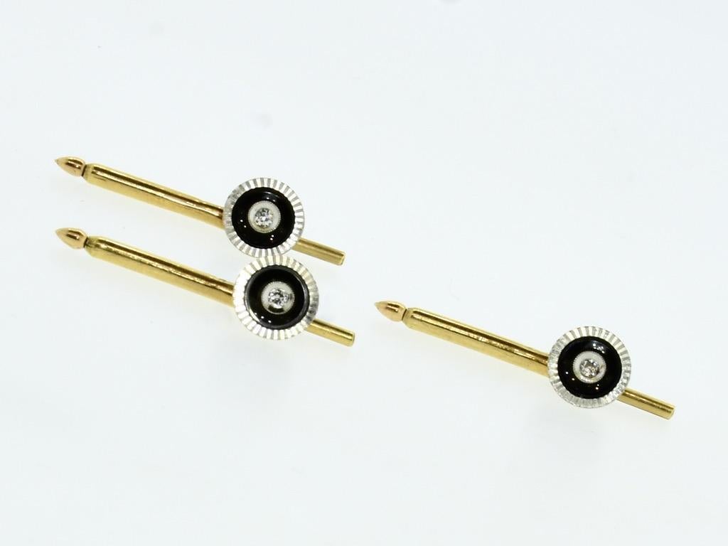 Art Deco tuxedo shirt studs crafted in 18k gold and platinum. Featuring European-cut white diamonds at the center, these studs exhibit a striking circular design. The platinum has been engraved with a geometric lines which creates a striking design