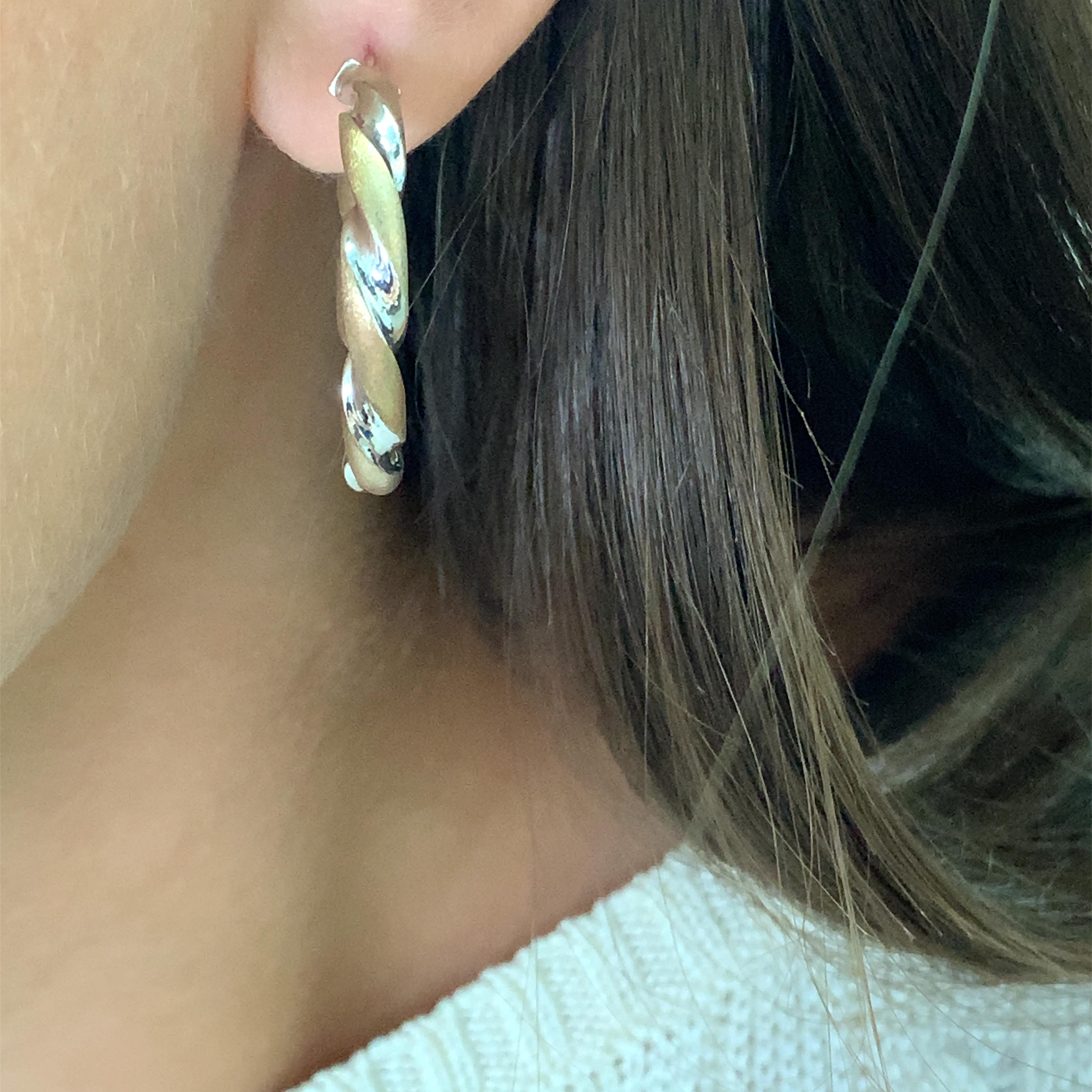 Elevate your jewellery collection with these stunning Art deco twist hoop earrings in 9k white and yellow gold. The matte finish of the earrings gives them a timeless elegance that is perfect for any occasion, be it a formal event or a casual