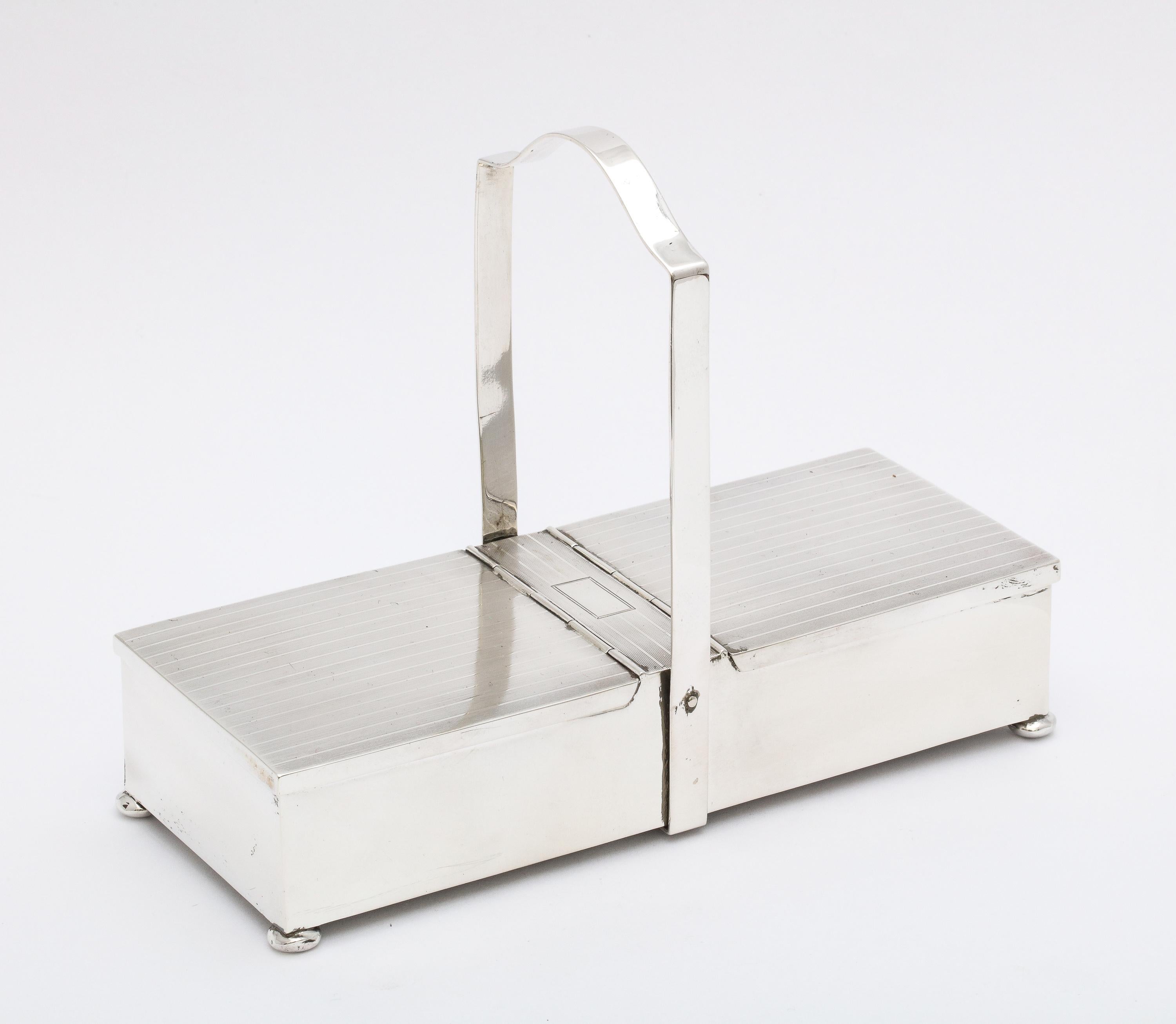 Unusual, Art Deco Period, sterling silver, two-compartment table box on bun feet and having two hinged lids and a handle, The Watrous Division of The International Silver Co., Meriden Connecticut, circa 1925. Box lids are tuxedo- striped in design;