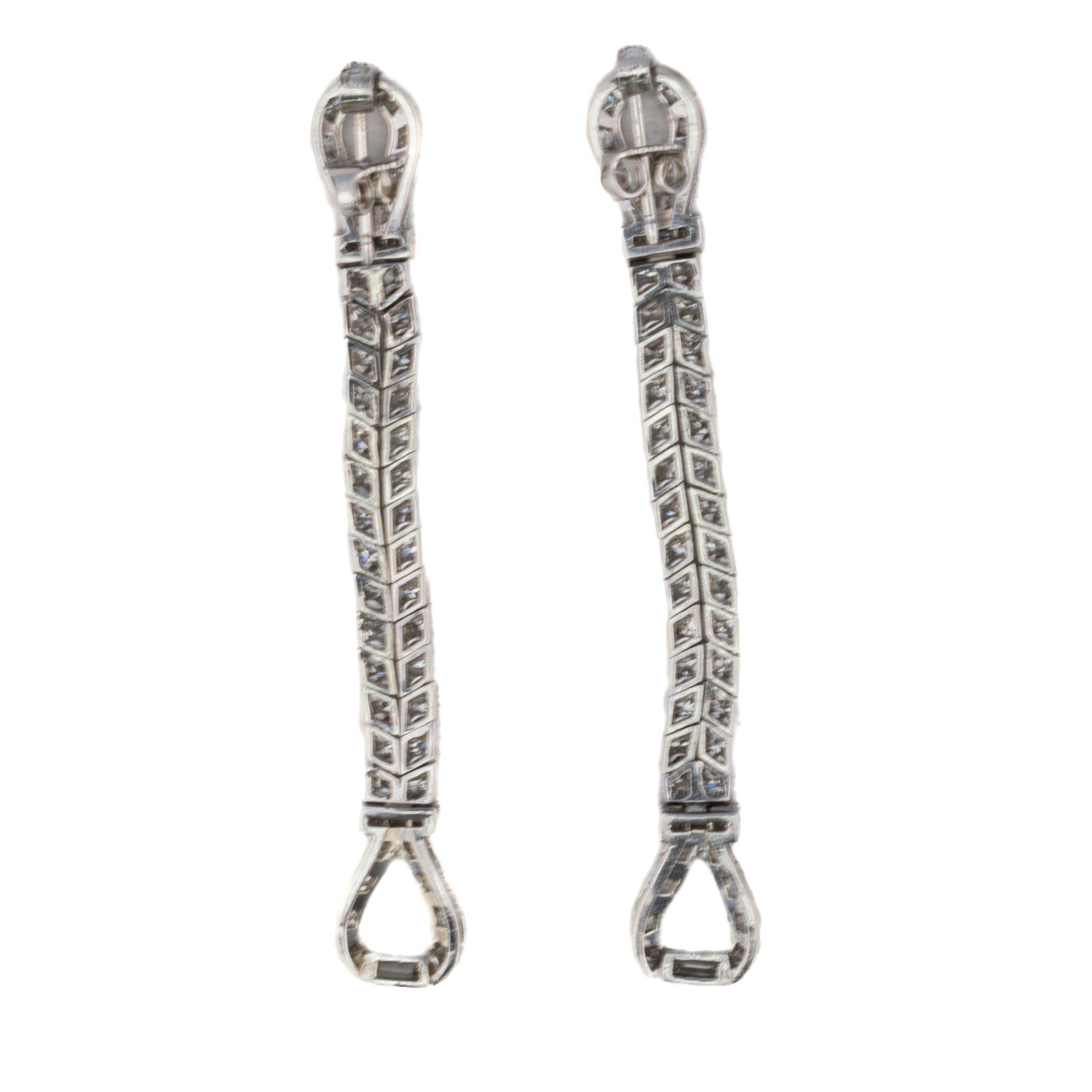 Art Deco Two Row Diamond Loop Earrings

Description:
These refined platinum earrings feature a graceful linear silhouette crafted with meticulous attention to detail. Composed of two rows of 53 round brilliant-cut diamonds accented by 2 baguette-cut