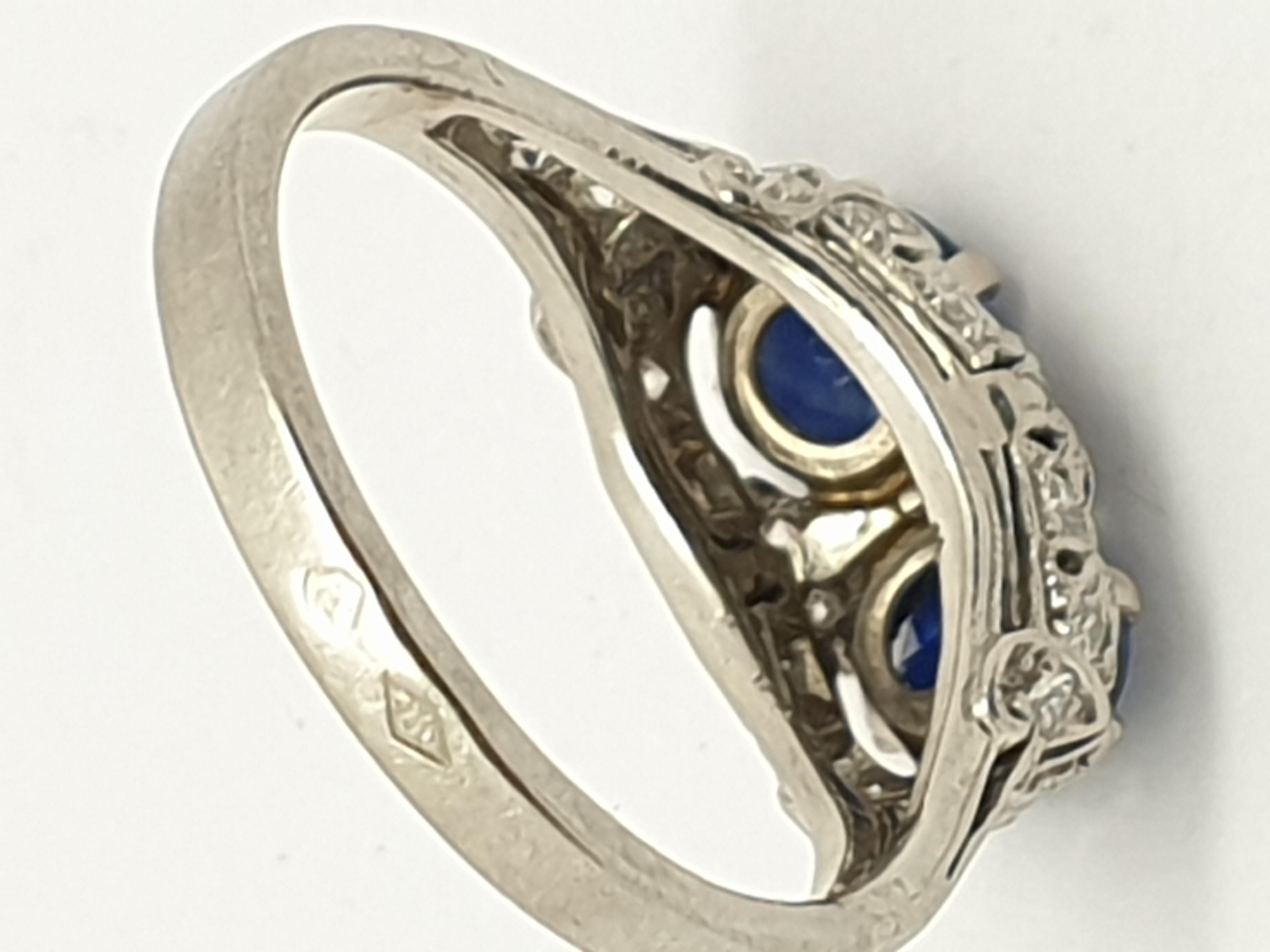Art Deco  sapphire diamond ring featuring two gorgeous 0.50ct each genuine natural blue round  Ceylon sapphires. The beautiful filigreed trellis that wraps around the sapphires and onto the shoulders of the band reveals the ring’s Art Deco