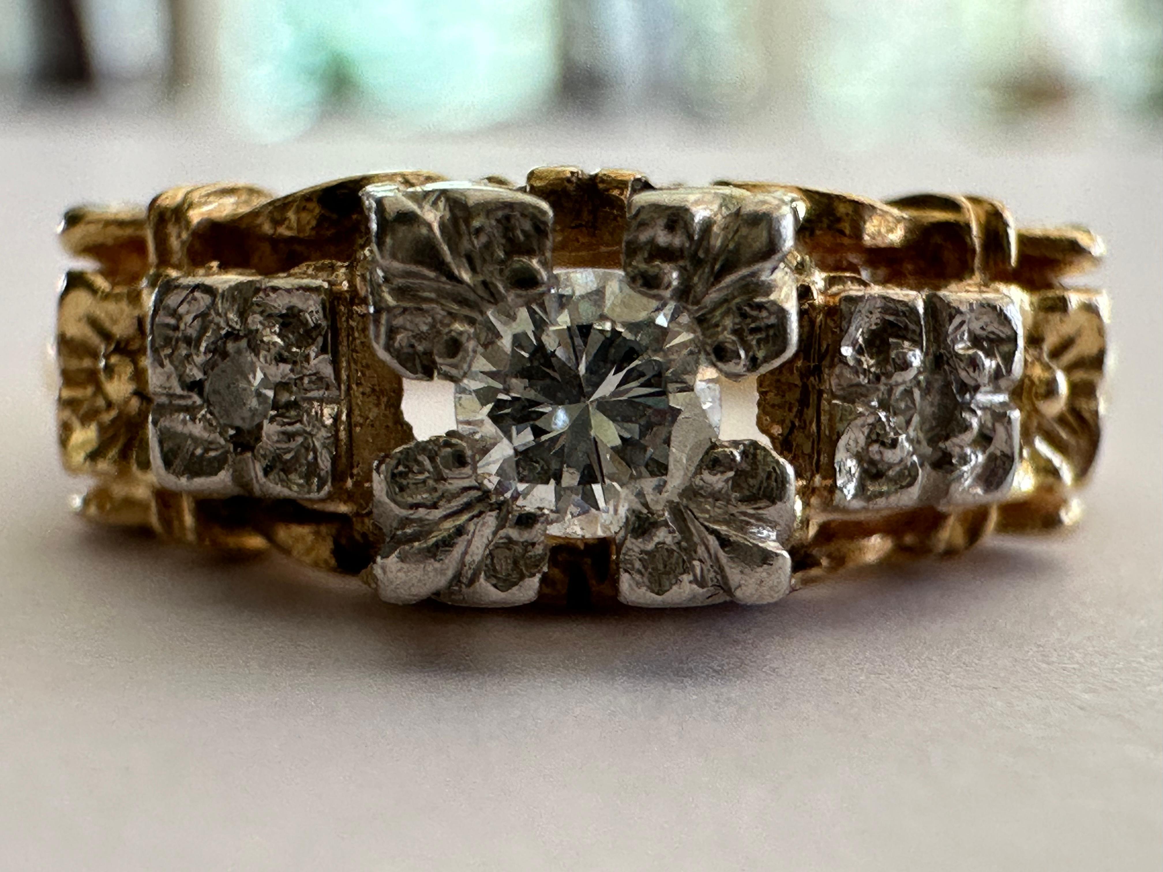 Crafted in the 1930s, this Art Deco gem features an Old European-cut diamond center stone measuring approximately 0.06 carat, F-G color VS clarity,  accented with two single cut diamonds and hand engraved flowers on the shoulders. Set in two tone