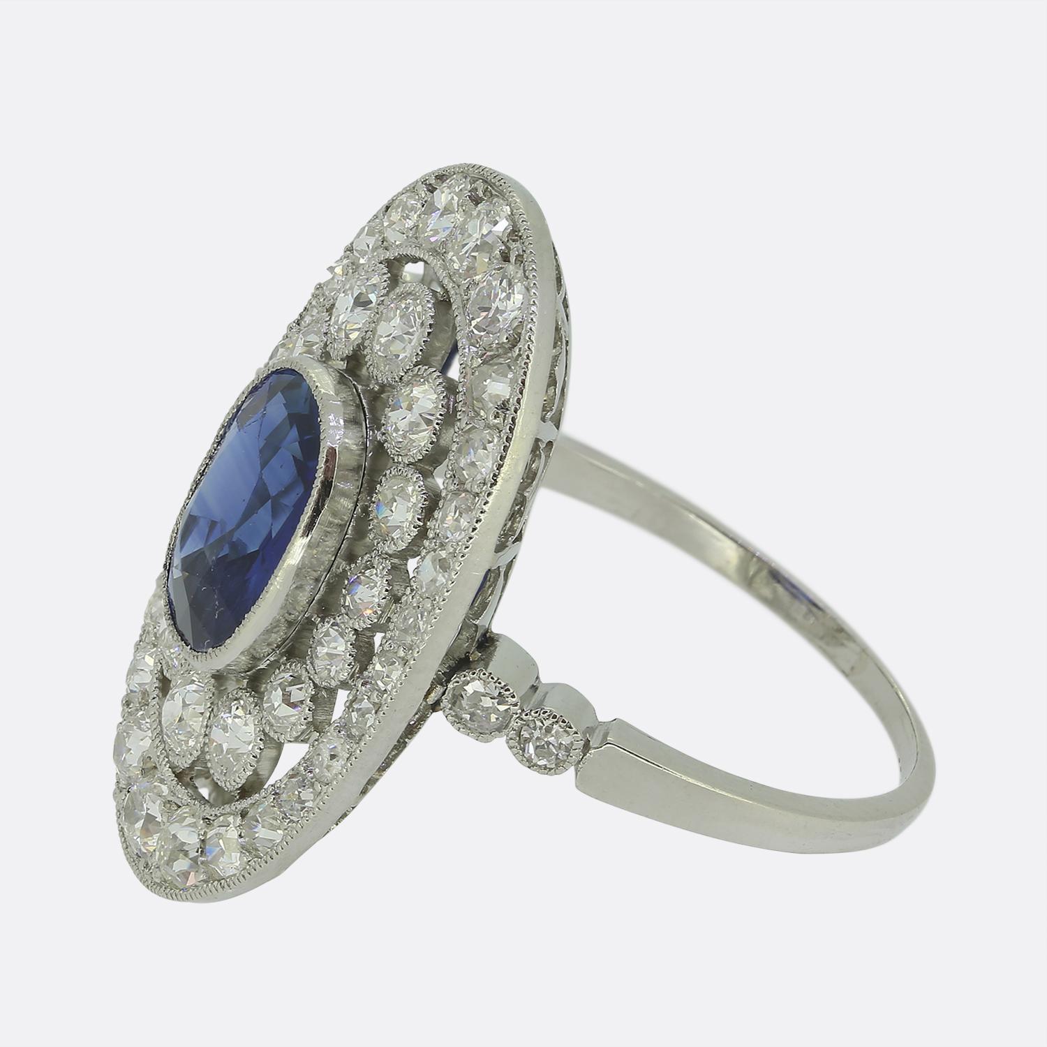 Ecco uno splendido anello a grappolo realizzato in un'epoca in cui lo stile Art Déco era all'avanguardia nel mondo del design. Al centro del quadrante troviamo un affascinante zaffiro blu naturale ovale sfaccettato. La pietra principale è