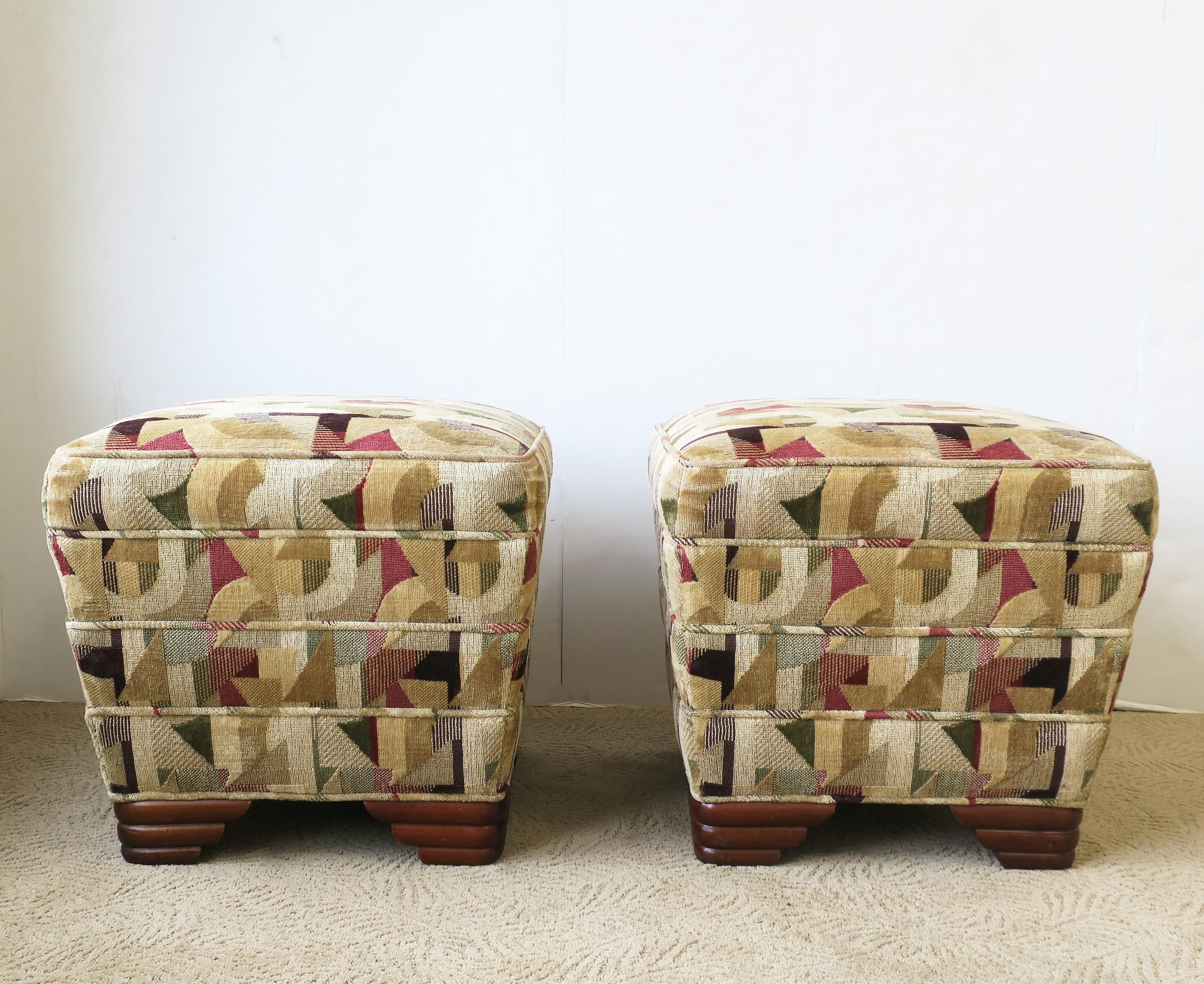 A pair of Art Deco upholstered ottomans, stools, or benches, circa late-20th century. A comfortable, firm pair with a graduated design, upholstered with welt detailing, finished with wood feet, all in the Art Deco design style. 

Dimensions: 
19