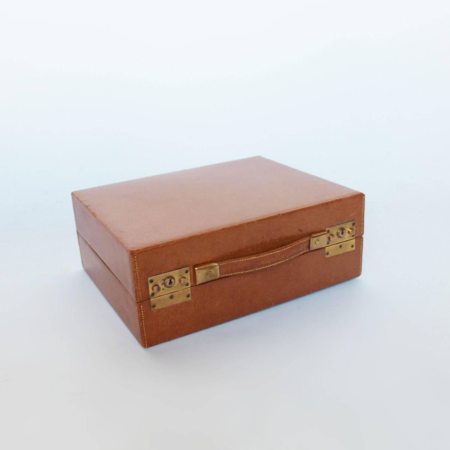 An Art Deco silver vanity case by Asprey of London. Leather travel case containing hair and clothes brushes, mirror, scent bottles, jewellery case and leather box, silver and glass boxes, as well as gilt scissors and shoe horn.
All silver engraved