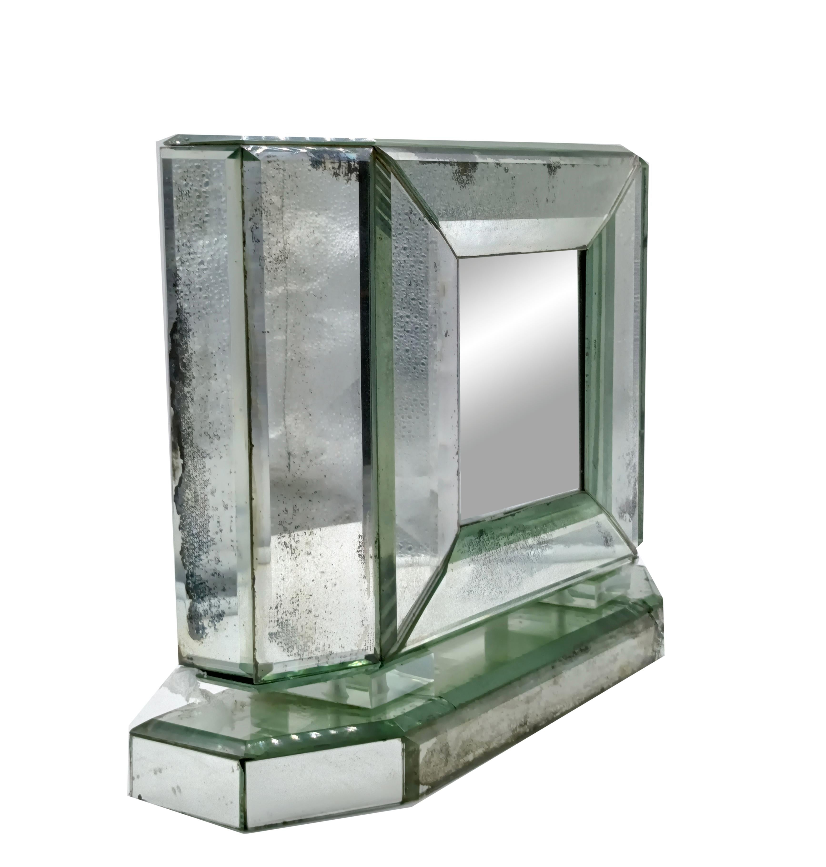 Miroir de table composé de miroirs biseautés et oxydés.
Chaque panneau de miroir est entièrement fabriqué à la main, comme le faisaient les premières manufactures de Murano dans la Venise du XVIIIe siècle. Elles sont argentées une à une,
