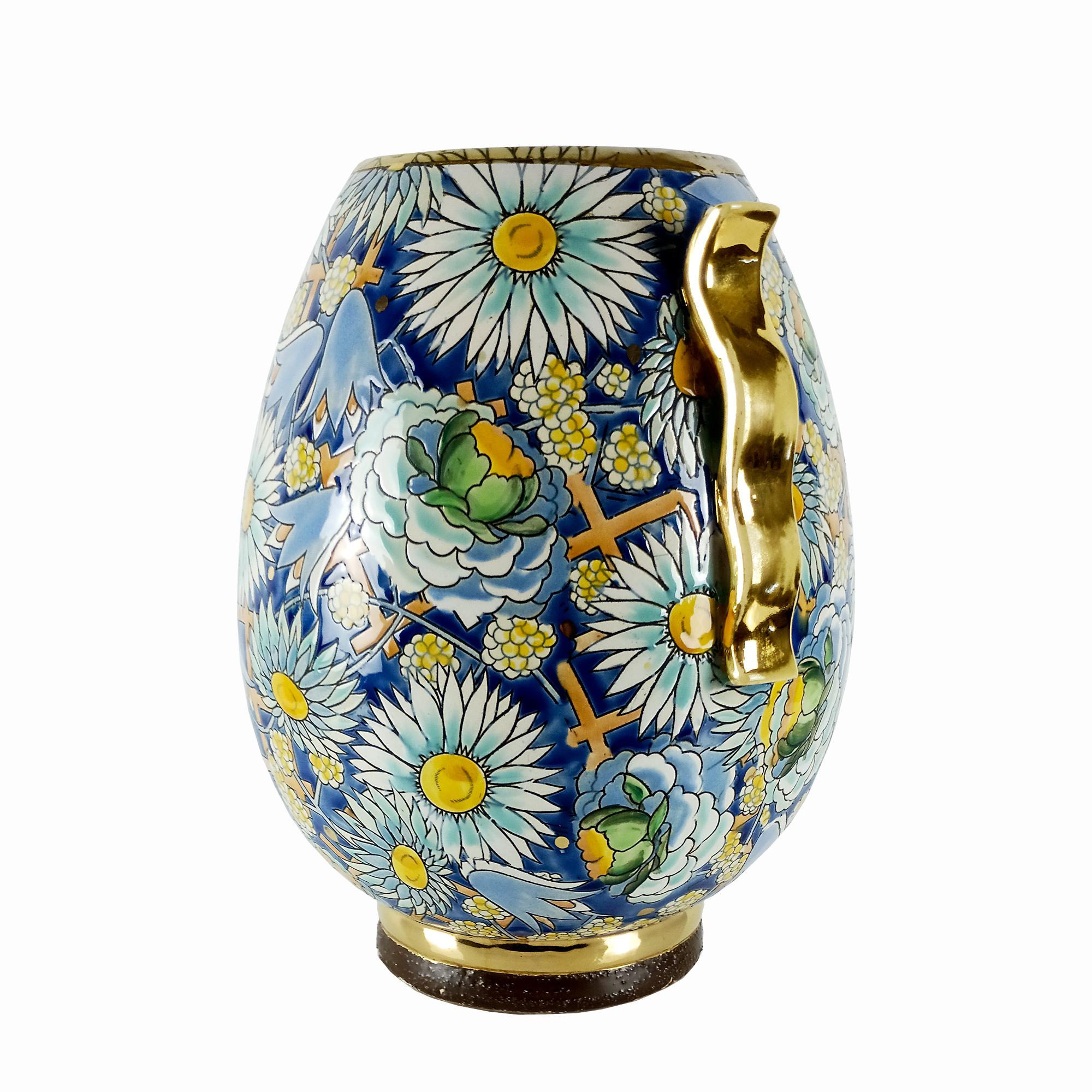 Art Deco Vase aus emaillierter Keramik mit floralen und geometrischen Motiven, teilweise vergoldete Henkel und Sockel.
Geschaffen von Raymond Chevallier (1900-1959), dem Nachfolger von Charles Catteau.
Herstellung: Boch La Louviere.

Belgien um 1925.