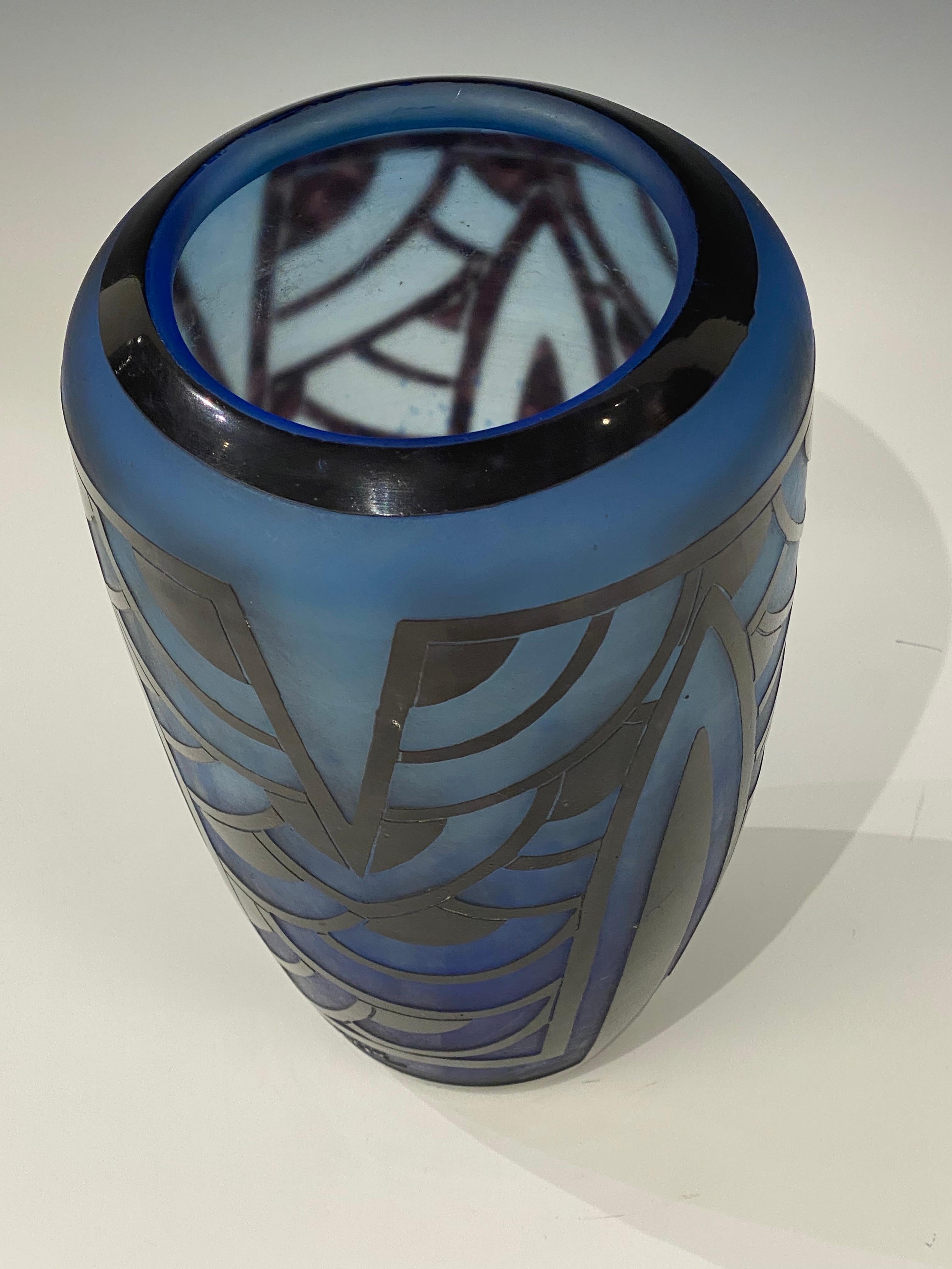 A flat ovoid-shaped glass vase with etched geometric designs done in Degradé of Blues.  This piece is one of the Nénuphar Serie from Le Verre Français.
Signature: Charder & Le Verre Français.

This piece is documented on page 203 of the Charles