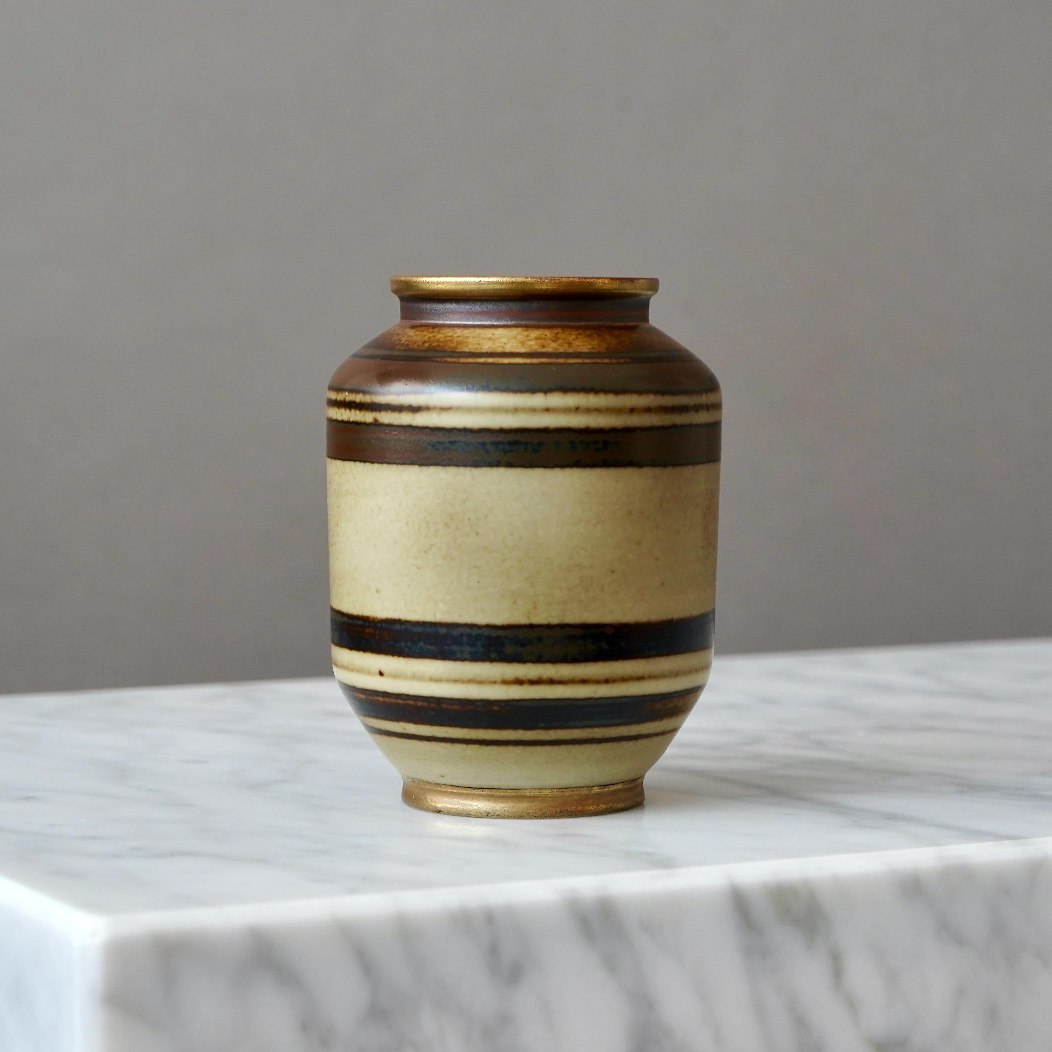 Un jarrón art déco de gres. Bonito esmalte con pie y boca detallados en oro.
Diseñado por Gunnar Nylund para ALP (Lidköpings Porslinsfabrik), Suecia, años 30.

Gran condición.
Impreso con tres estrellas, 