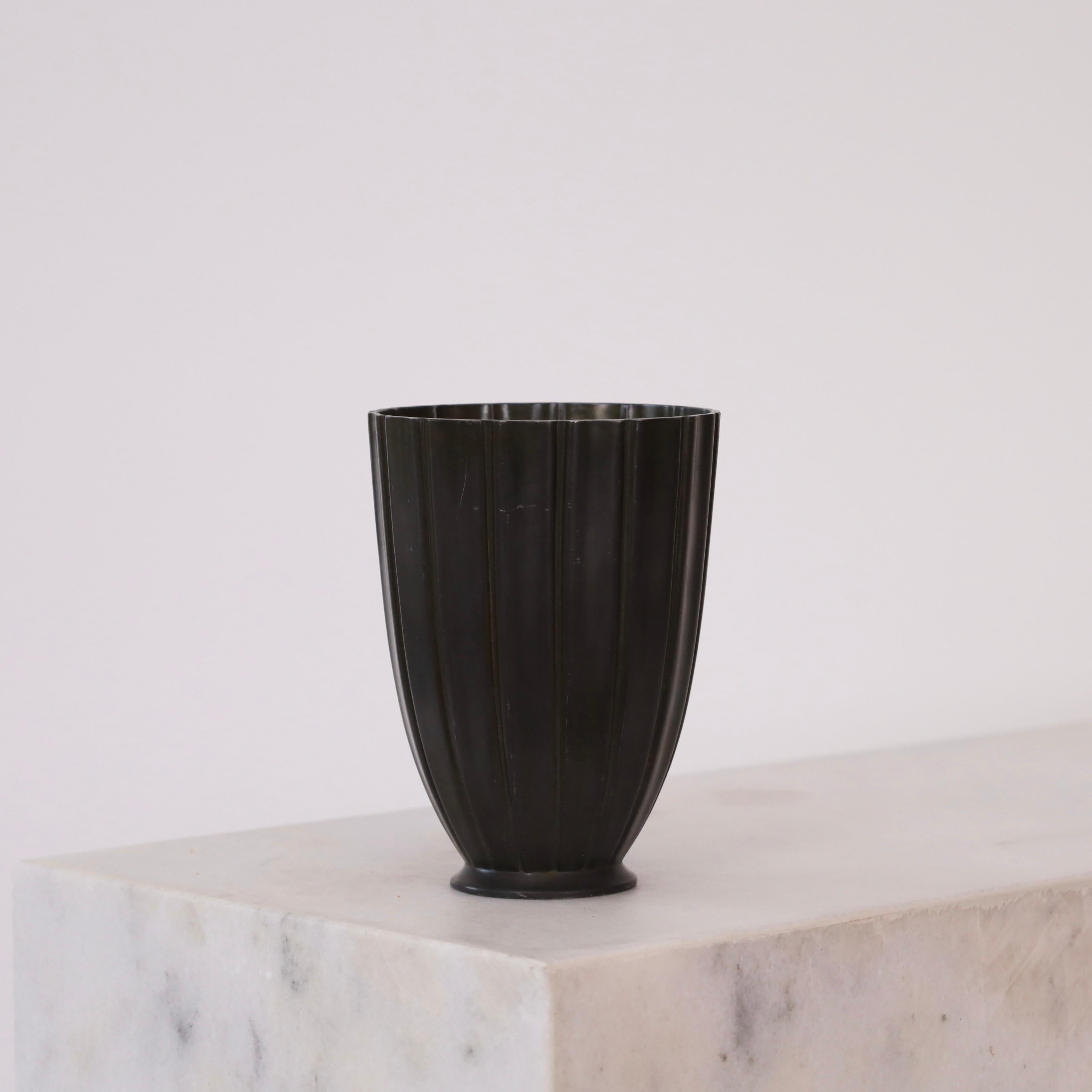 A metal vase with vertical lines designed by Just Andersen in the 1942. A fine piece for a beautiful spot.

* A metal vase with vertical lines on a small foot
* Designer: Just Andersen
* Model: D2363 (stamped 'Just 2363')
* Year: 1942
* Condition: