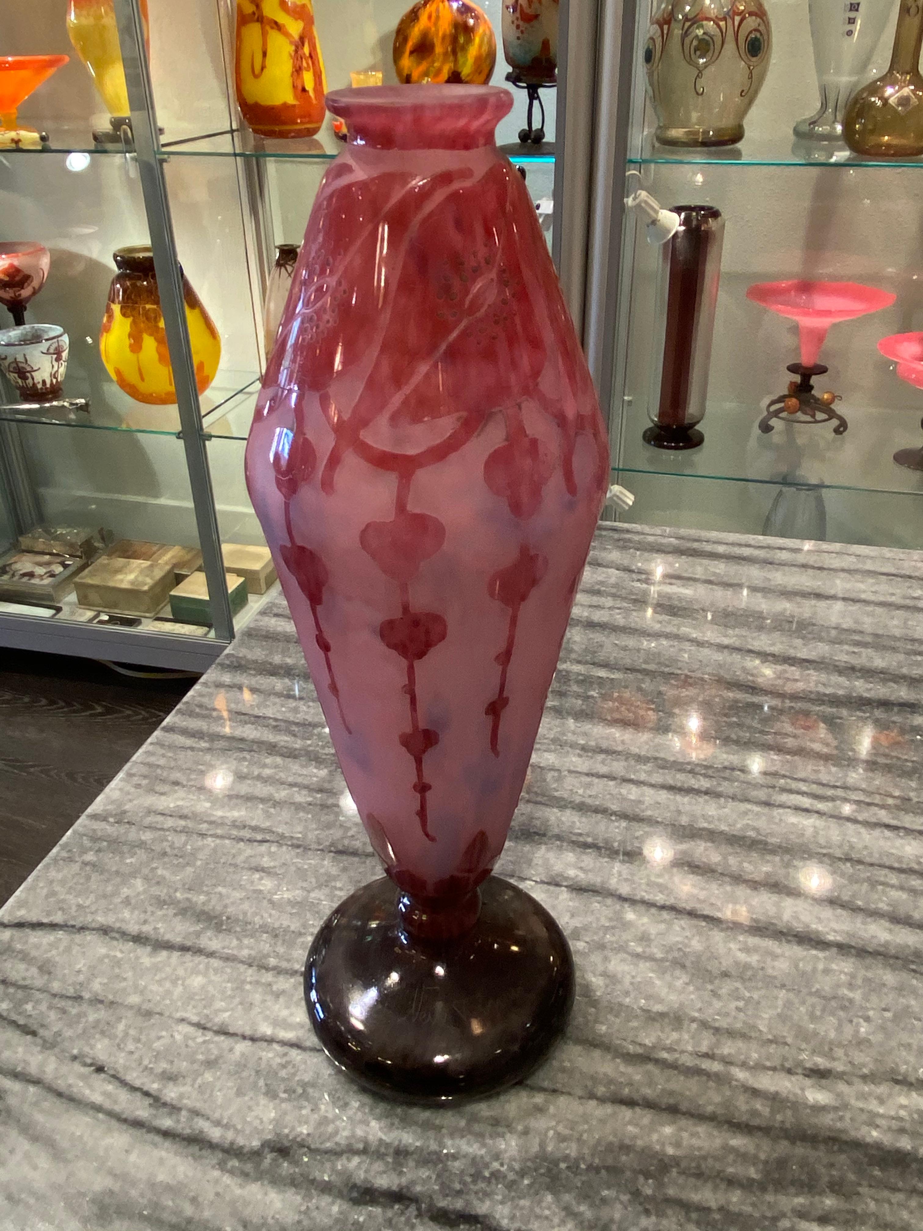 A Mottled Pale Pink satiné and Blue glass vase overlaid with Dark Pink to Violet flower wreath.  The pattern is acid-etched. The foot and stem of this vase are in Violet. This piece belongs to the Garances serie from Le Verre Français.  
Signature: