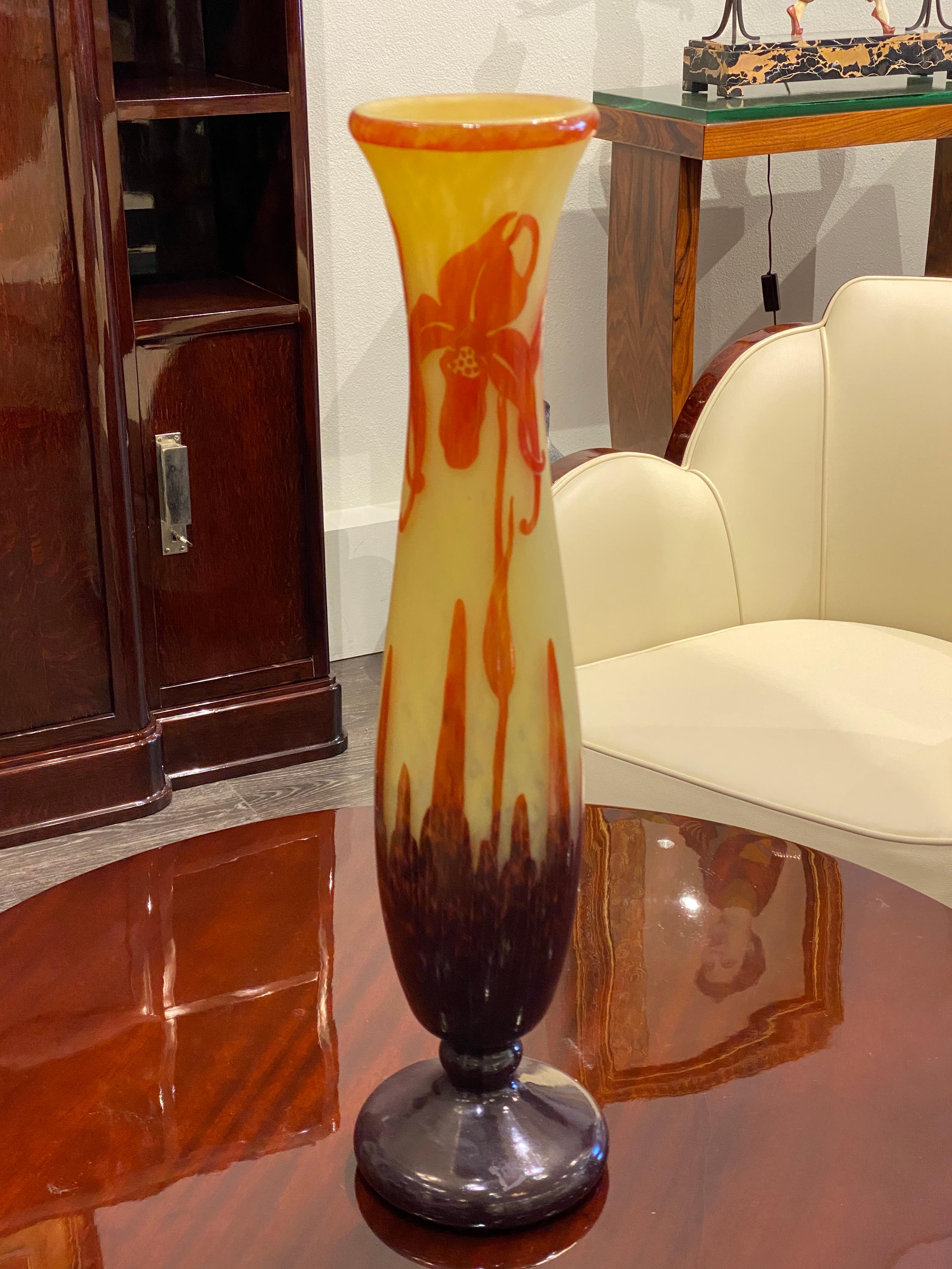 A cylindrical-shaped glass vase in Yellow overlaid with Red to Violet pattern.  The pattern is acid-etched and resembles the 