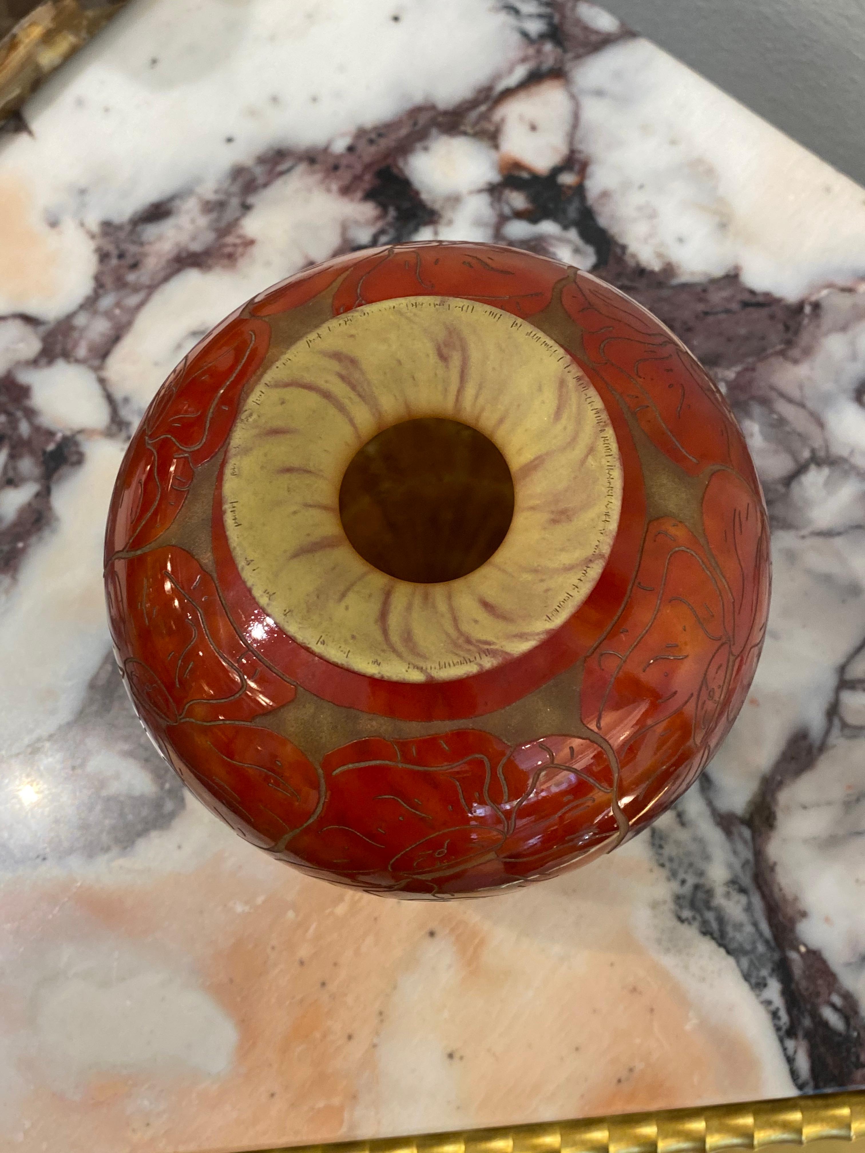 A small round-shaped glass vase with flowers in Red-Orange with a Satiné Matte Bright Yellow background. The foot of this vase is in Violet.  The pattern is acid-etched.  This piece is from one of the most popular designs/patterns, Pavots, from Le