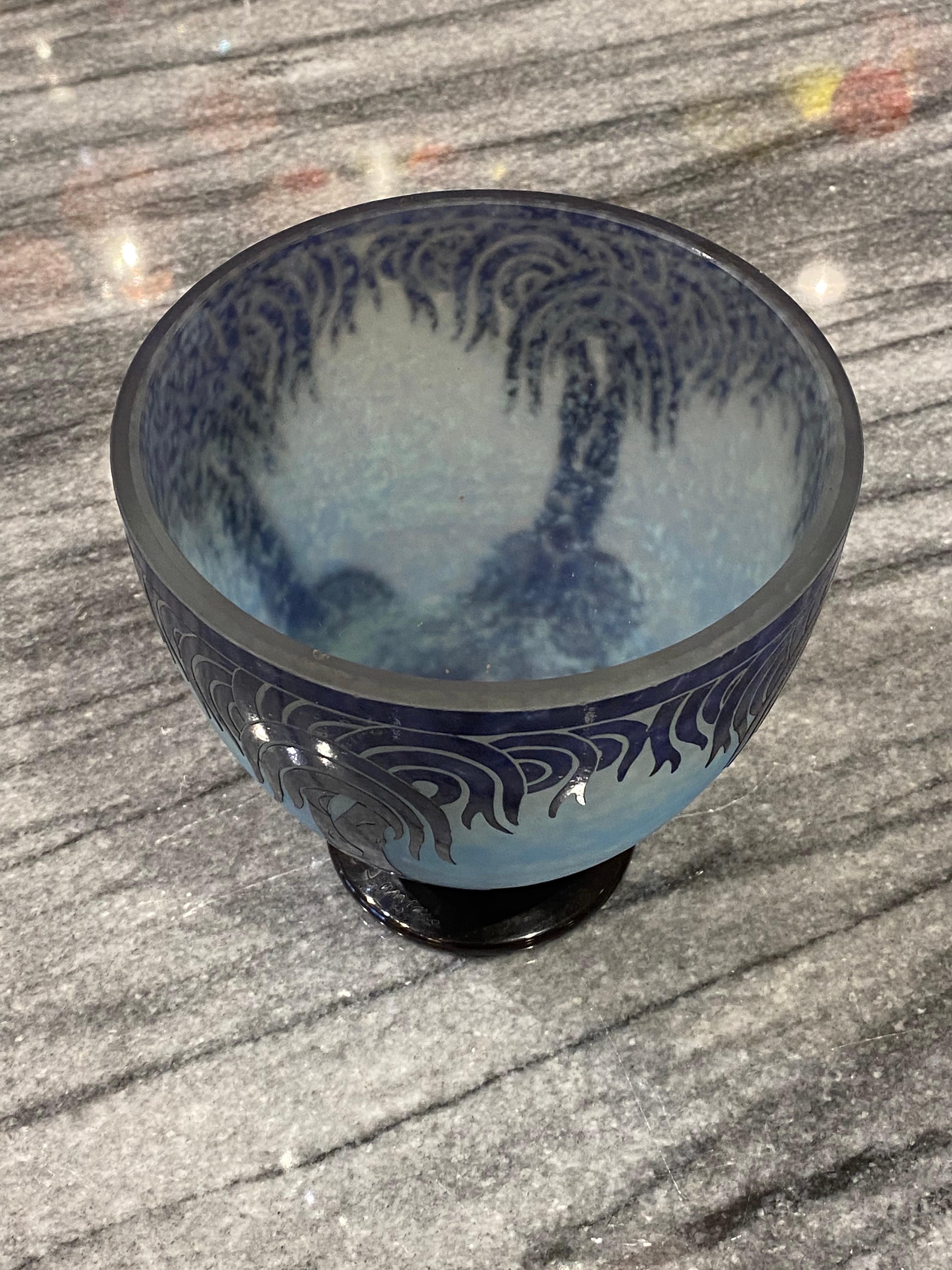 Un vase en verre se dégradant en bleu clair, recouvert d'un bleu plus foncé.  Le motif 