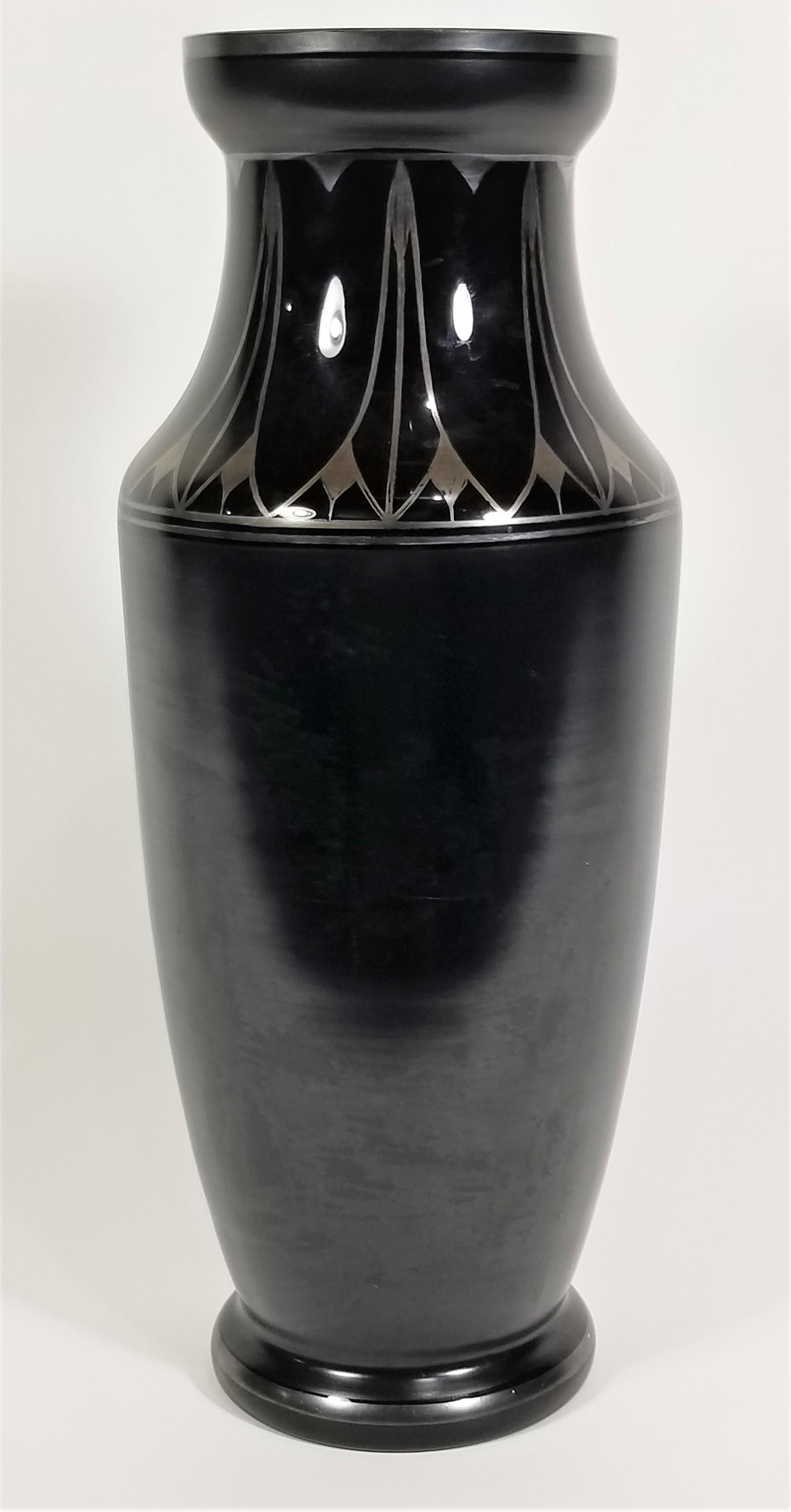 Art Deco black glass vase with silver inlay. Marked Czechoslovakia.

Measurements:
Height: 13.0 inches
Top Diameter: 3.88 inches
Middle Diameter: 5.13 inches.