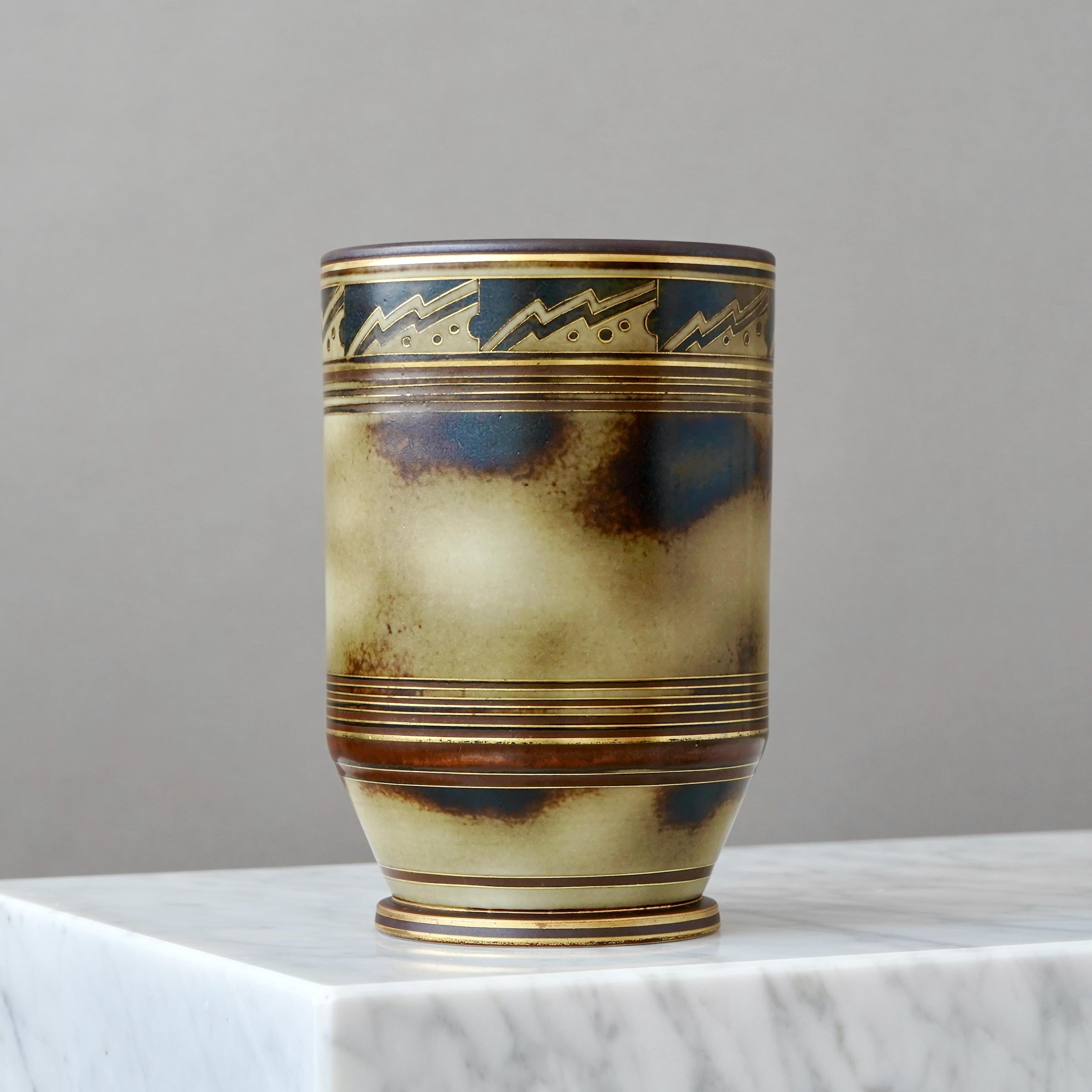 Un bellissimo vaso in gres art déco. Smalto sorprendente con dettagli dipinti a mano in oro.
Disegnata da Gunnar Nylund per ALP (Lidköping Porslinsfabrik), Svezia, anni '30.

Buone condizioni, qualche segno di usura sull'oro.
Timbro 