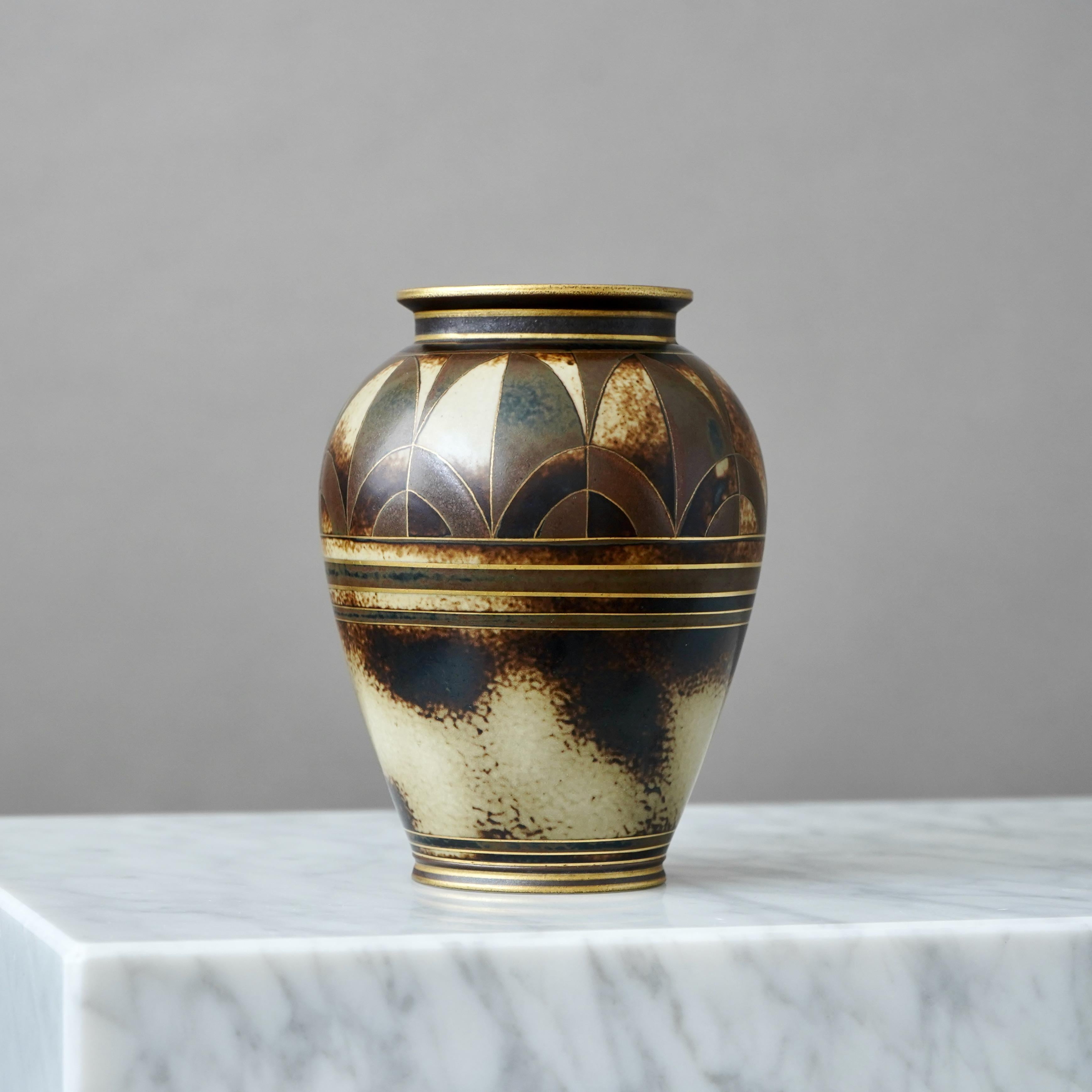 Un bellissimo vaso in gres art déco. Smalto sorprendente con dettagli dipinti a mano in oro.
Disegnata da Gunnar Nylund per ALP (Lidköping Porslinsfabrik), Svezia, anni '30.

Ottime condizioni, solo una leggera usura dell'oro.
Timbro 