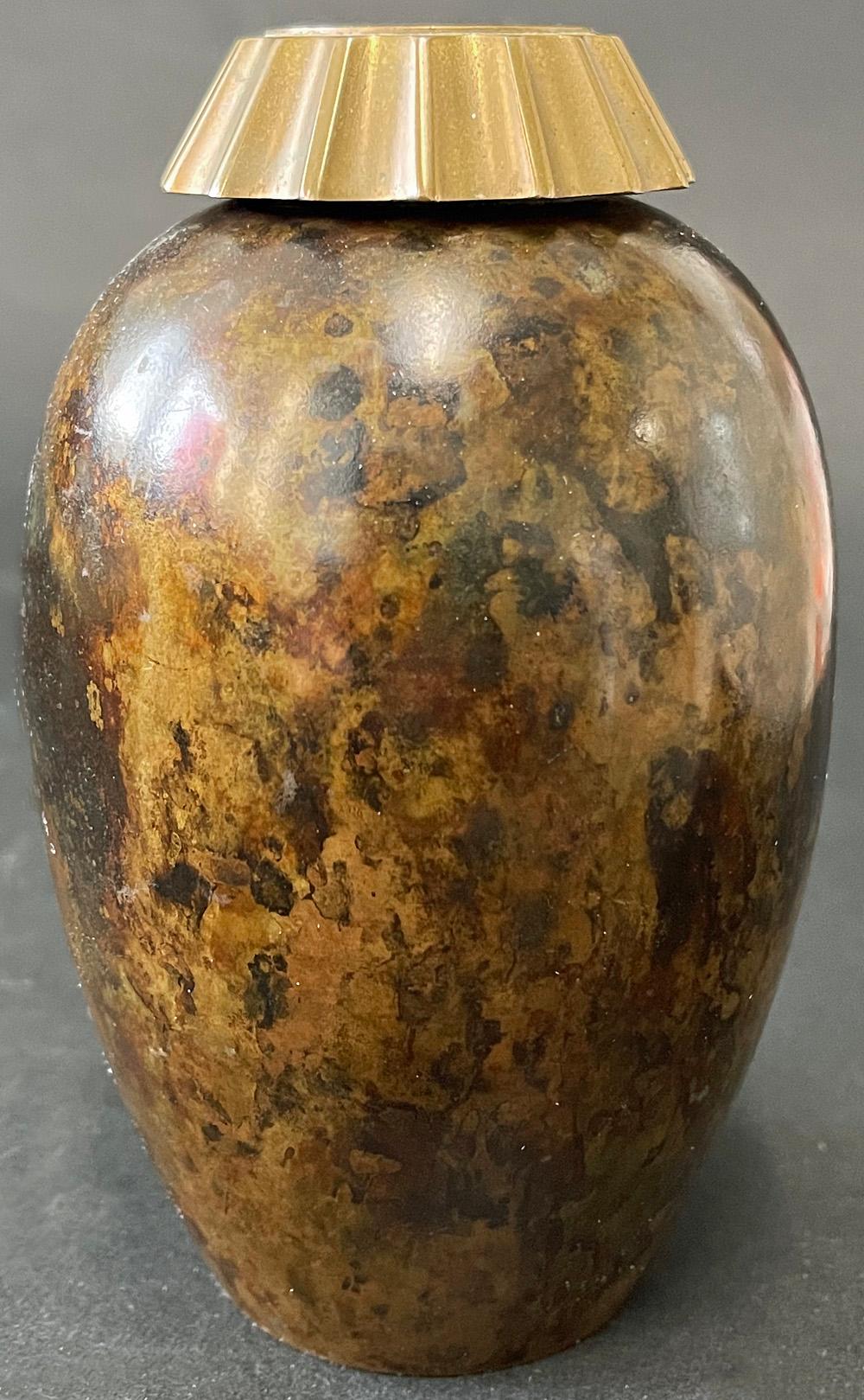 Bellamente acabado con una rara pátina moteada, este inusual y muy escaso jarrón de bronce Art Decó de Evan Jensen presenta un inserto de bronce con cuello acanalado que distingue la obra de Jensen de la de sus contemporáneos de Dinamarca y otros